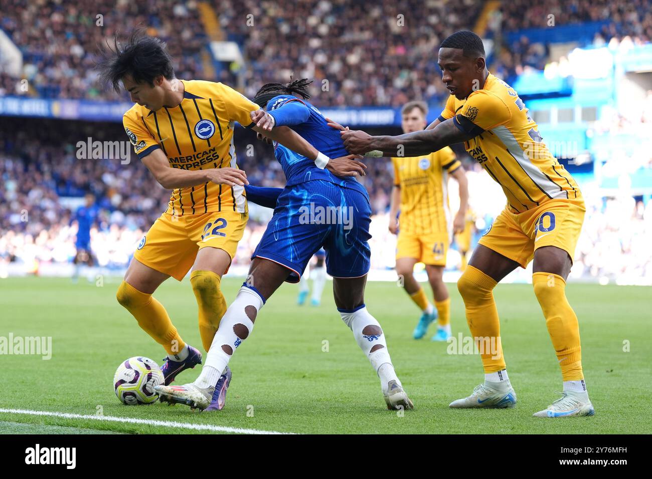 Noni Madueke de Chelsea (au centre) se bat pour le ballon contre Kaoru Mitoma de Brighton et Hove Albion (à gauche) et Carlos Baleba lors du match de premier League à Stamford Bridge, Londres. Date de la photo : samedi 28 septembre 2024. Banque D'Images