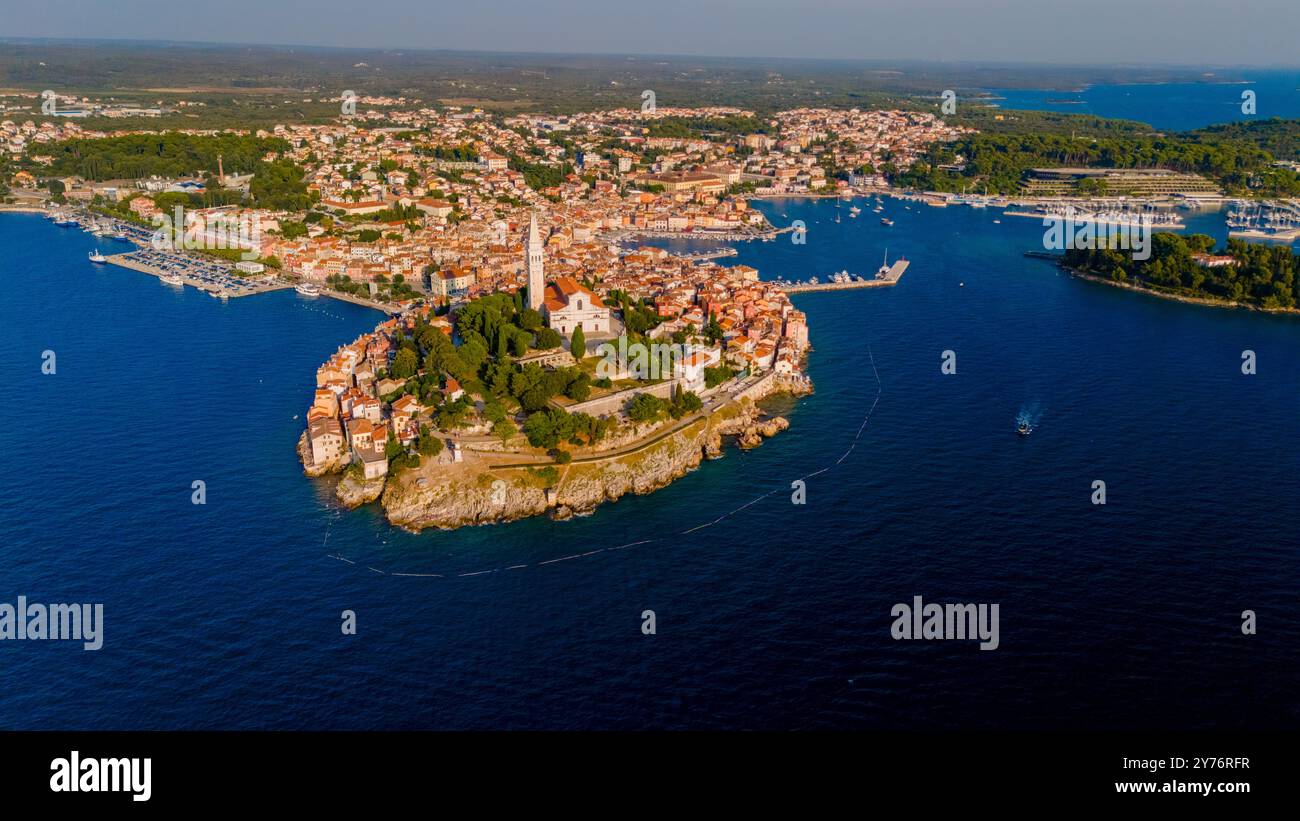 Rovinj Croatie le paysage vibrant prend vie d'en haut, avec une charmante architecture méditerranéenne nichée sur une péninsule rocheuse. Les eaux ensoleillées embrassent la ville pittoresque, vue drone Banque D'Images