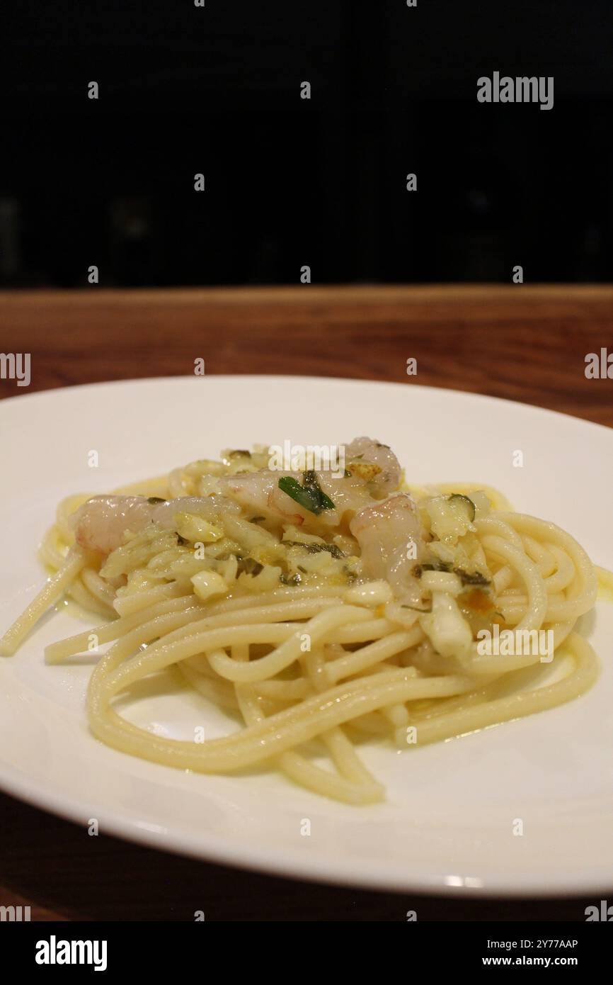 Cuisine italienne : bucatini aux crevettes et zeste de citron Banque D'Images