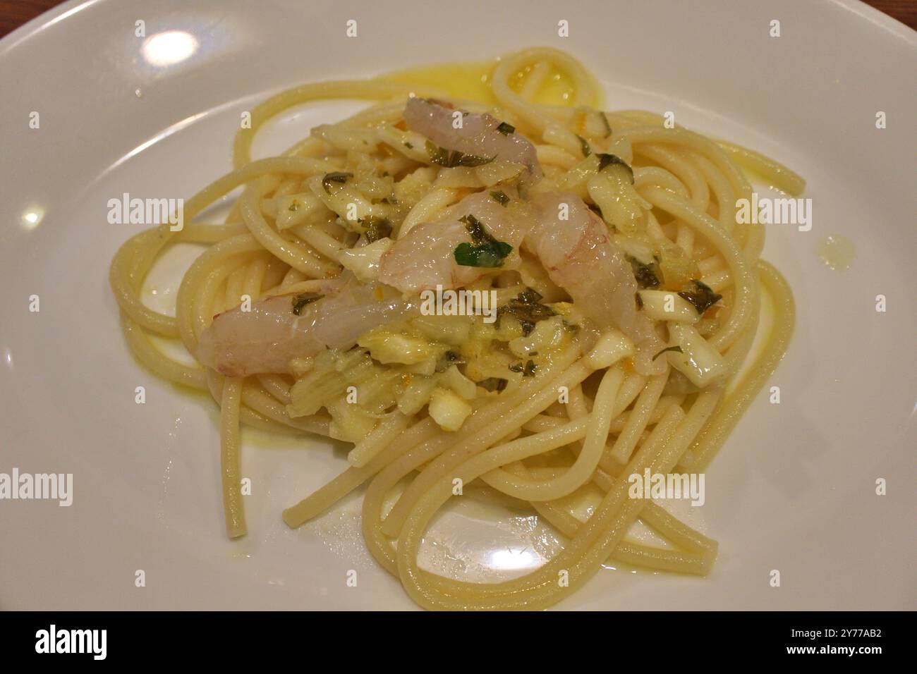 Cuisine italienne : bucatini aux crevettes et zeste de citron Banque D'Images