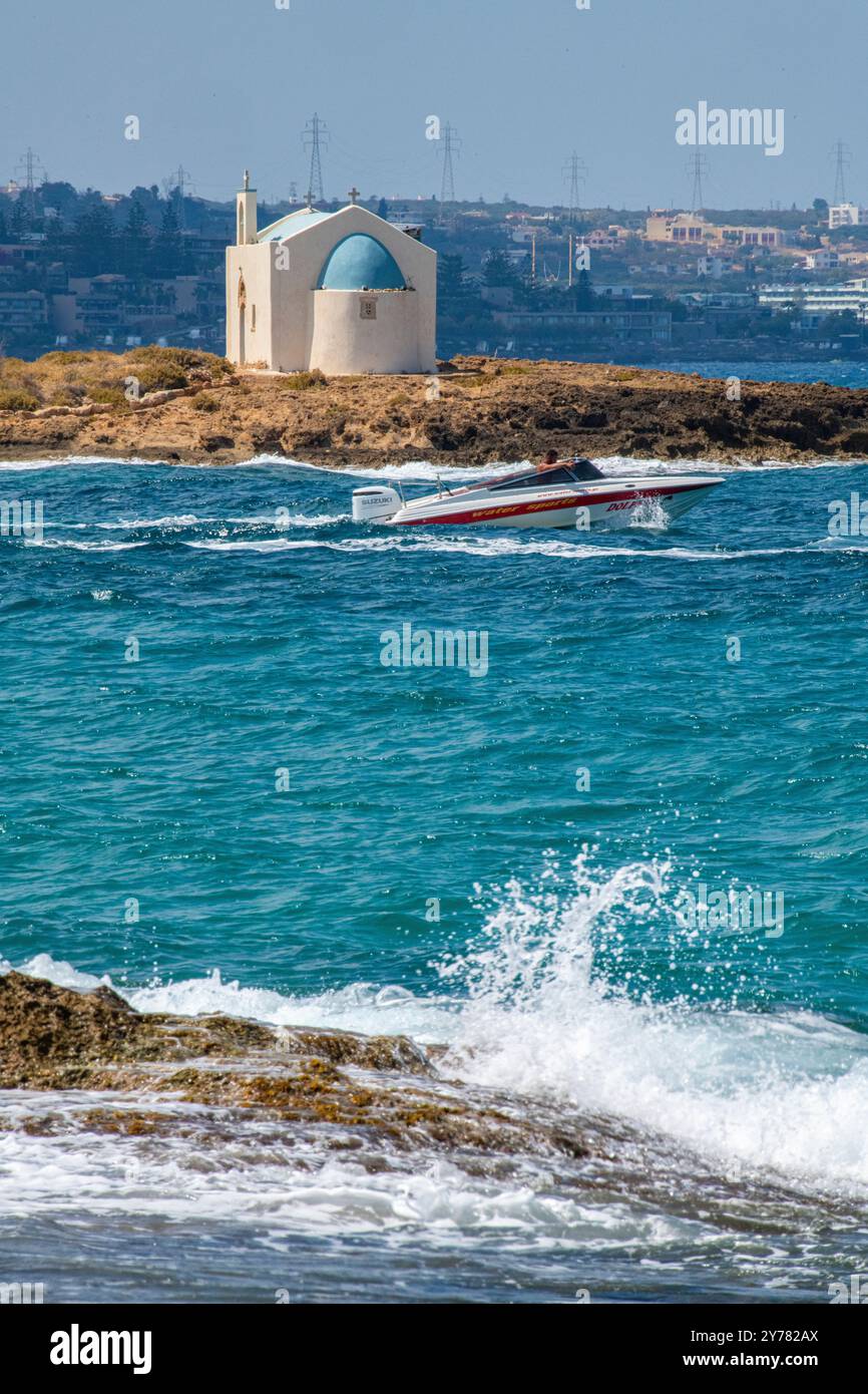 Vagues rugueuses et arrosage encadrent la chapelle Afentis Christos à Malia, en Crète Banque D'Images