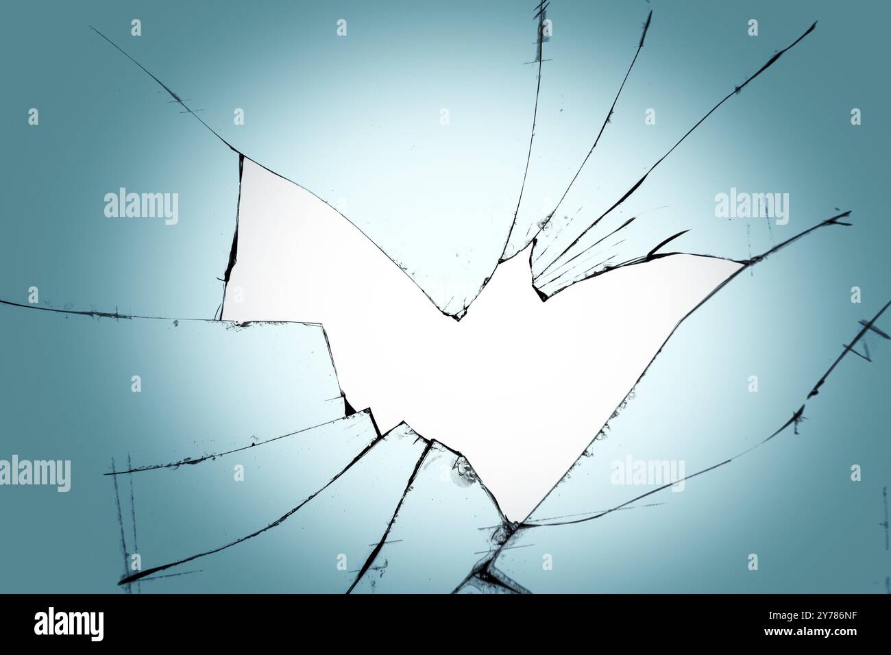 Un trou avec des fissures sur le verre. Fenêtre cassée sur fond bleu Banque D'Images