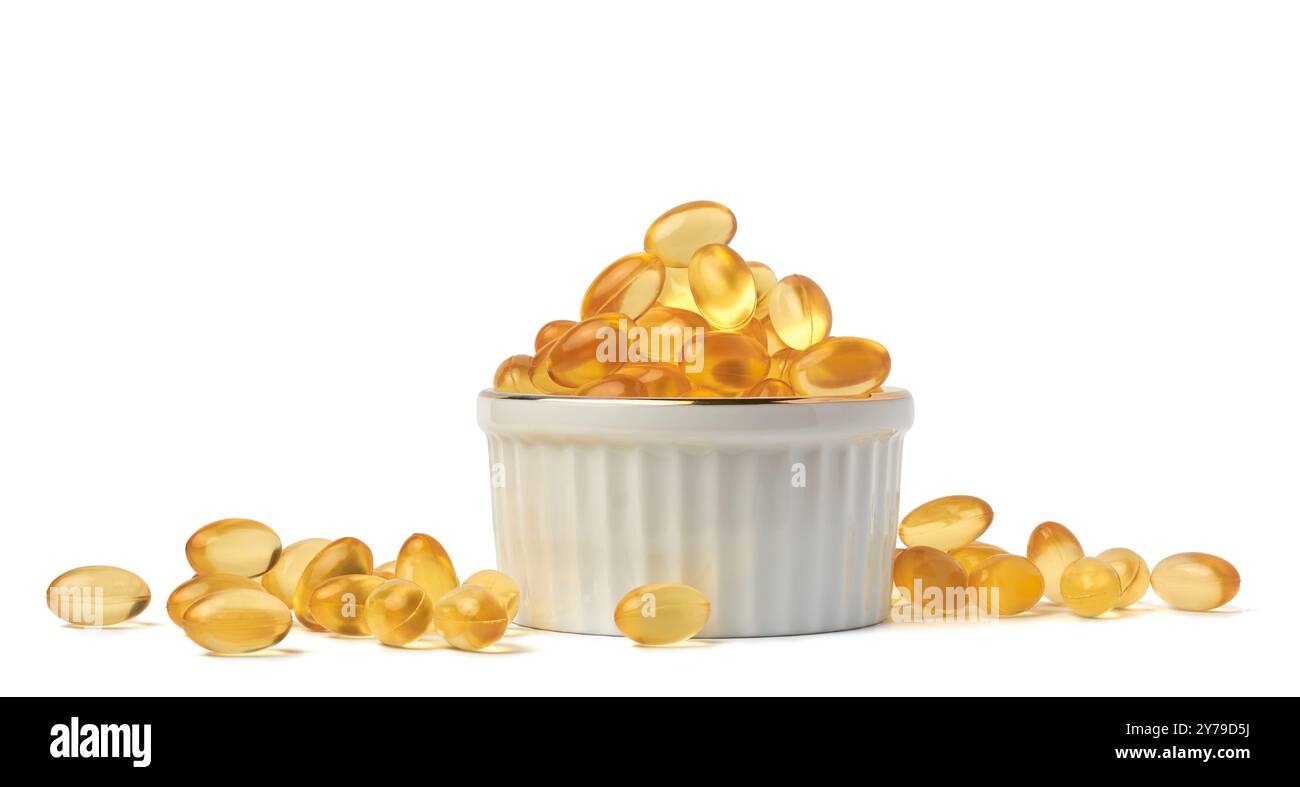 capsules d'huile de poisson ou pilules dans la tasse fond blanc isolé, compléments alimentaires riches en acides gras oméga 3 dispersés Banque D'Images