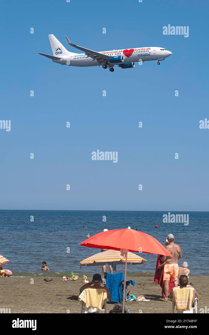 Larnaca, Chypre - 17 juillet 2022 : avion de la compagnie aérienne AirExplore survolant les touristes se relaxant sur McKenzie Beach Banque D'Images