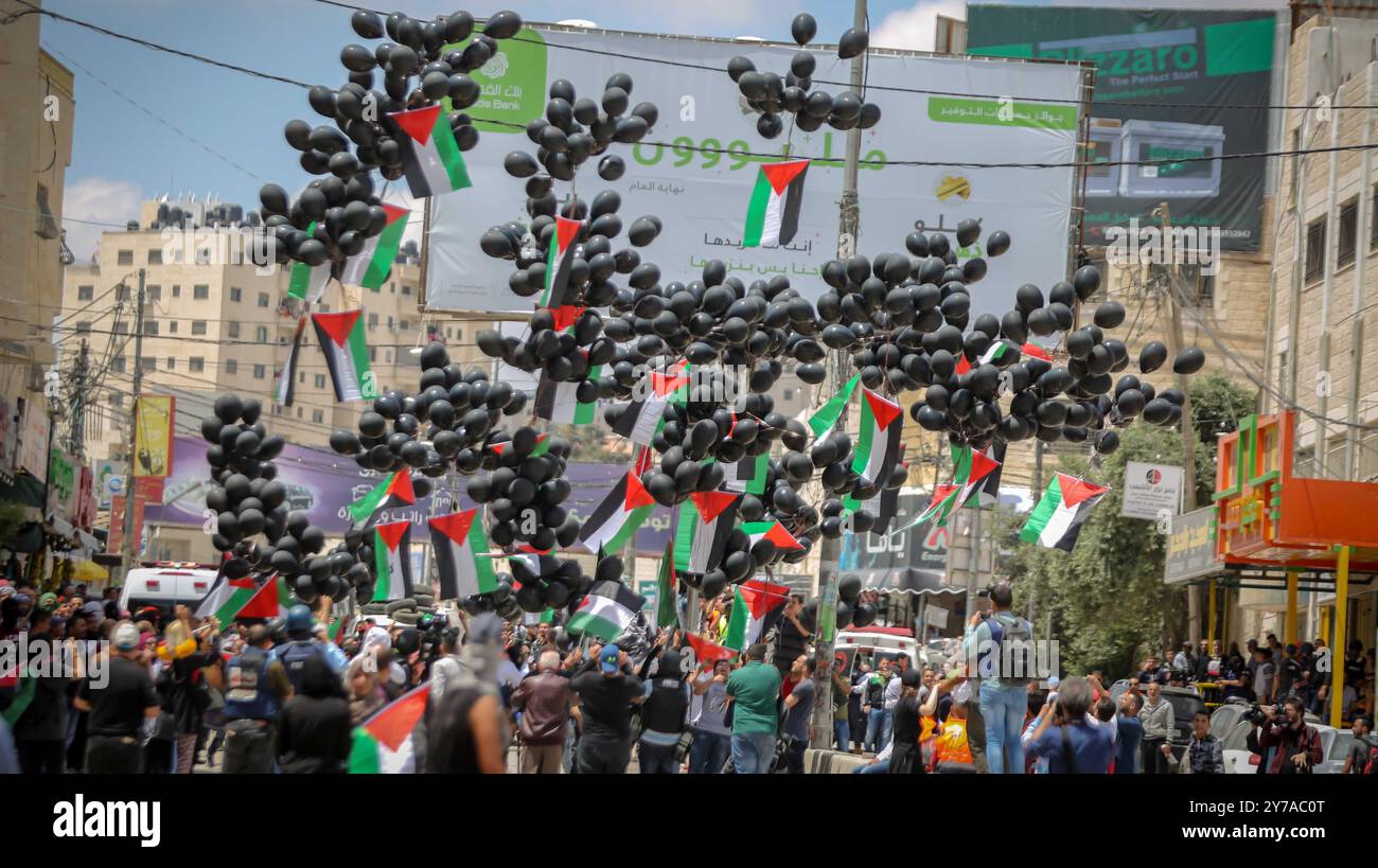 Des manifestants palestiniens lâchent des ballons noirs arborant des drapeaux palestiniens lors d'une manifestation marquant le 70e anniversaire de la Nakba, dans la ville de Ramallah, en Cisjordanie, le 14 mai 2018. Selon les médias, au moins 41 Palestiniens ont été tués et plus de 1800 blessés lors d'affrontements à la frontière Gaza-Israël lors d'affrontements contre le déplacement de l'ambassade américaine à Jérusalem ainsi que pour marquer la Journée de la Nakba. Banque D'Images