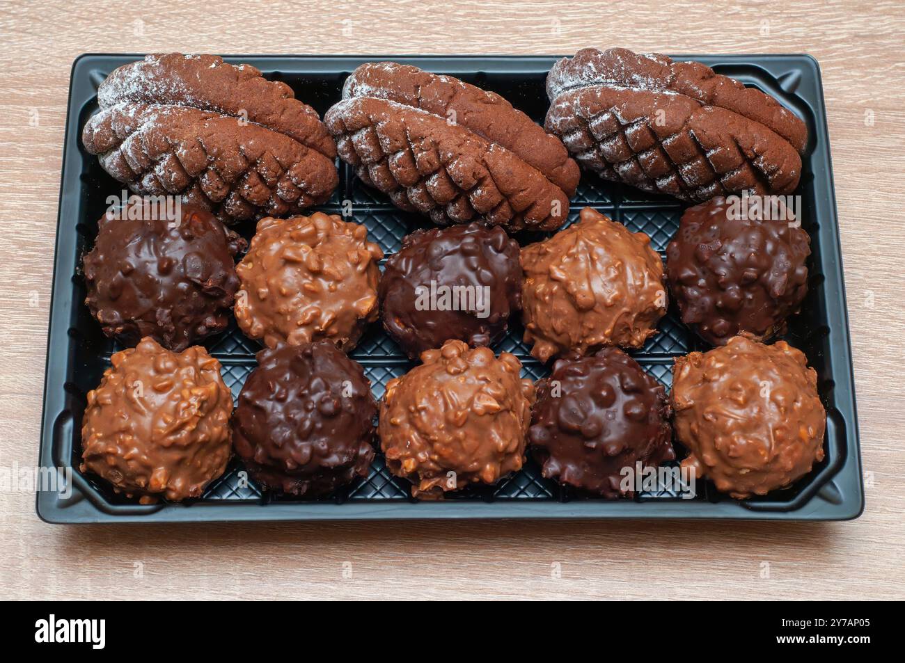 Assortiment de biscuits en forme de cône de pin chocolat et de friandises enrobées de chocolat dans un plateau festif. Banque D'Images