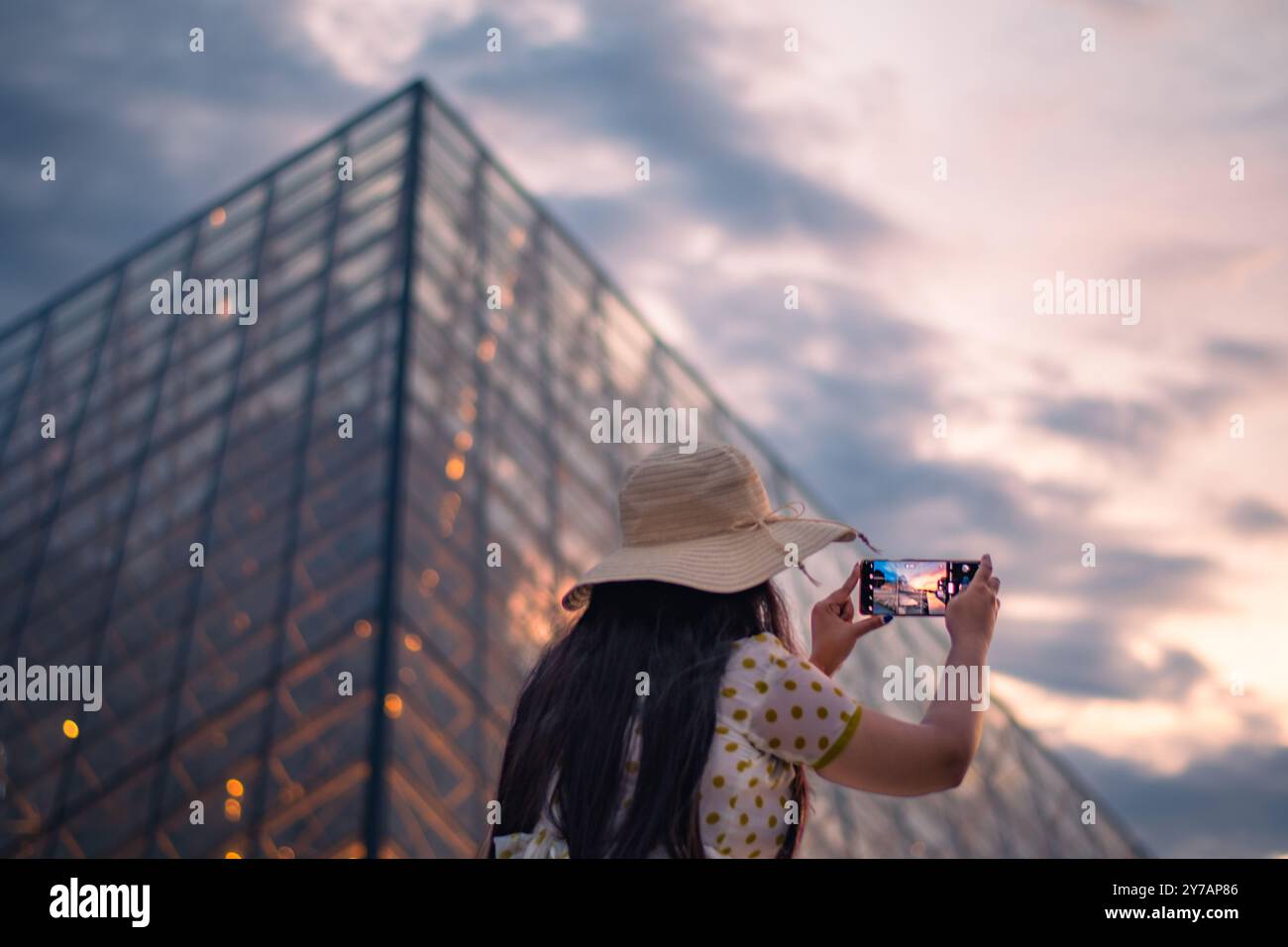 Une belle femme prenant des photos devant le musée du Louvre, l'un des plus grands musées du monde et monument historique. Un repère central de Pa Banque D'Images