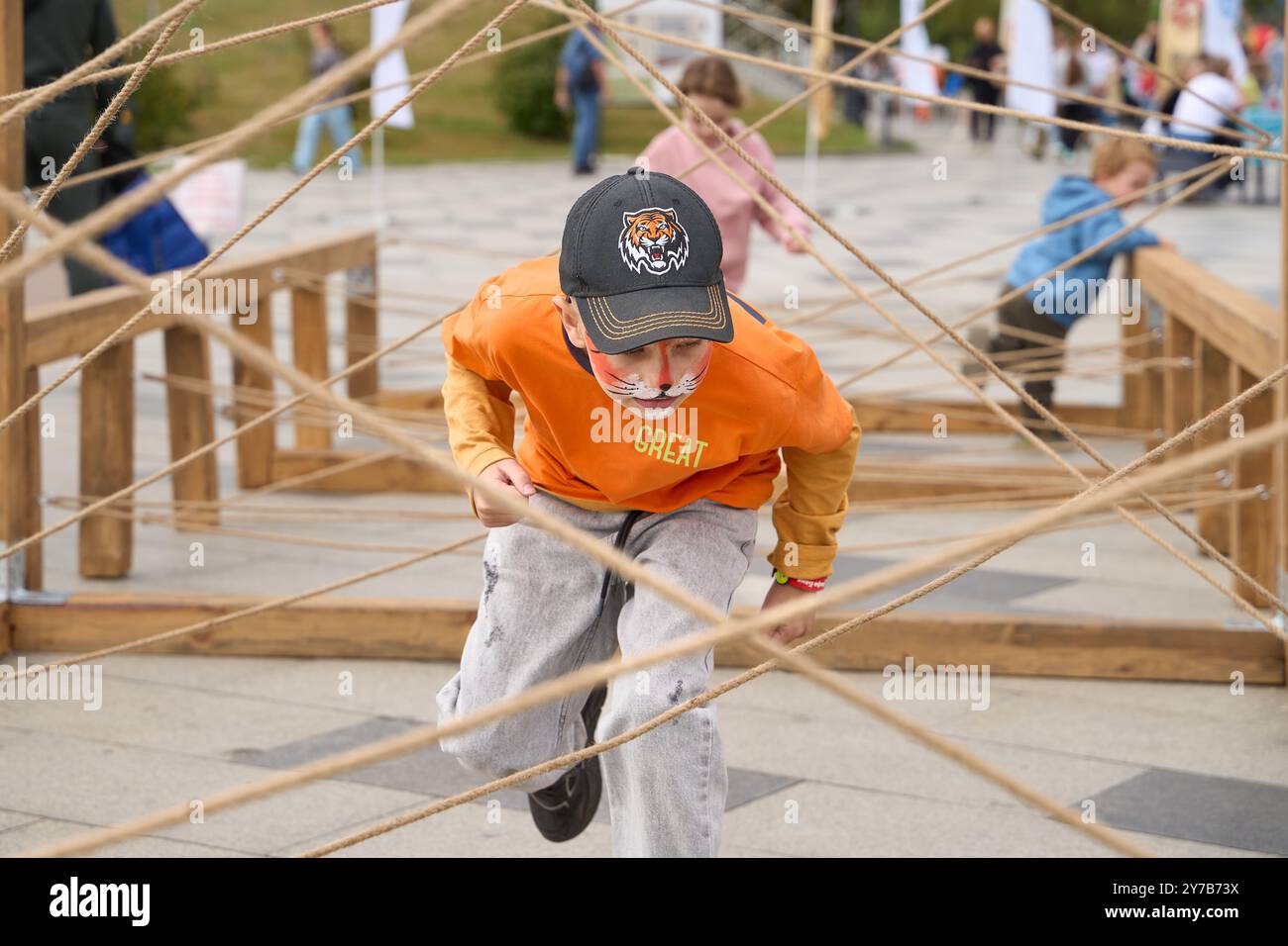 Vladivostok, Russie. 29 septembre 2024. Les enfants participent à un jeu de labyrinthe de corde lors de l'événement 'Tiger Day' à Vladivostok, Russie, le 29 septembre 2024. Depuis l'année 2000, le dernier dimanche de septembre est le 'jour du tigre' en Russie. Dimanche, la ville de Vladivostok a accueilli une variété d'événements colorés pour promouvoir la sensibilisation à la protection des tigres et autres animaux sauvages. Crédit : Guo Feizhou/Xinhua/Alamy Live News Banque D'Images