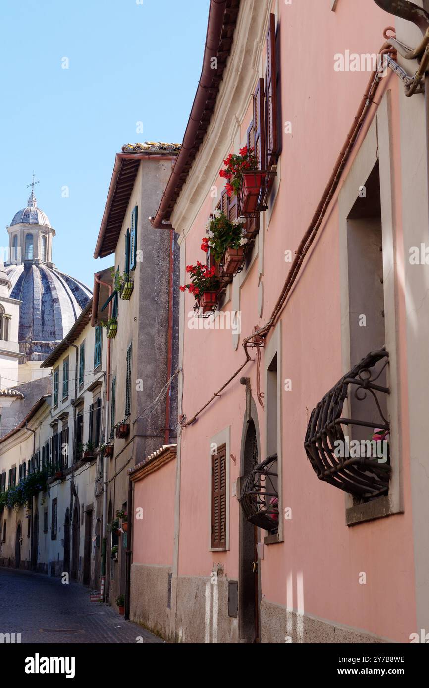 Rue étroite avec fleurs et dôme cathédrale dans le centre historique de la ville de Montefiascone, région du Latium, Italie. Septembre 28/29 2024 Banque D'Images