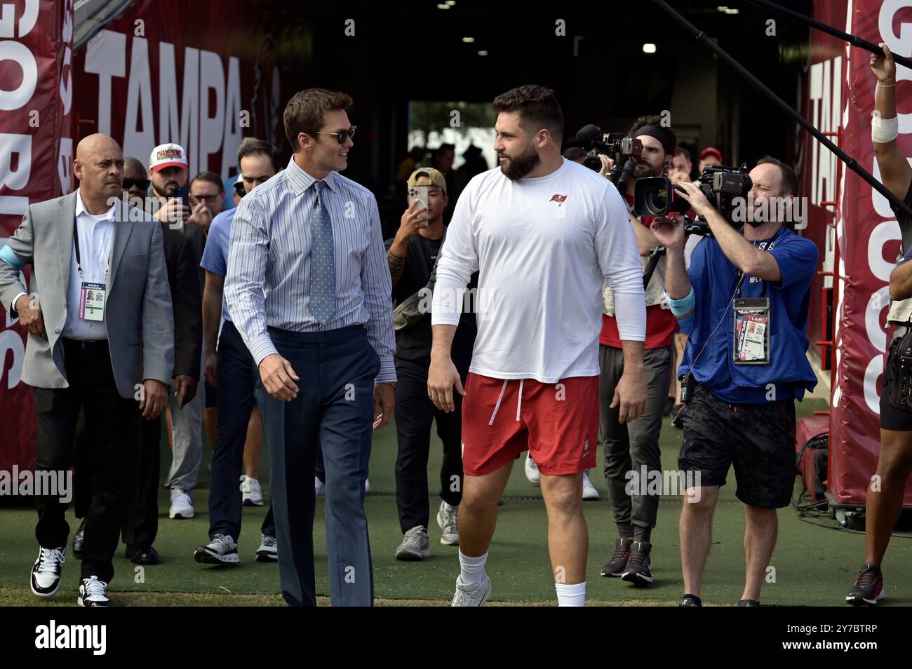 Tampa, États-Unis. 29 septembre 2024. Tom Brady (G), ancien quarterback des Buccaneers de Tampa Bay, discute avec Robert Hainsey, le centre de Tampa Bay, alors qu’ils marchent vers le terrain avant un match contre les Eagles de Philadelphie au Raymond James Stadium de Tampa, Floride, le dimanche 29 septembre 2024. Brady fait partie de l'équipe de diffusion du jeu. Photo de Steve Nesius/UPI crédit : UPI/Alamy Live News Banque D'Images