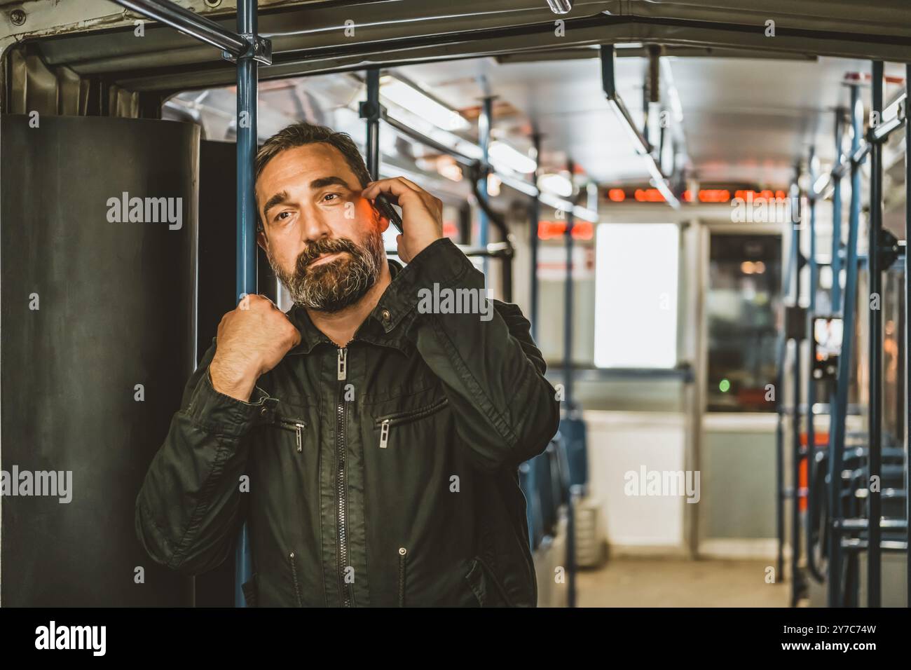 Personnes, style de vie, voyages et transports publics. Homme attrayant parlant au téléphone dans le bus public. Banque D'Images