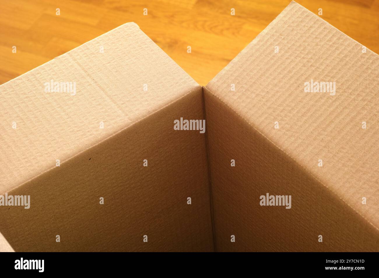 Boîte en carton vide sur un plancher en bois. Gros plan. Banque D'Images