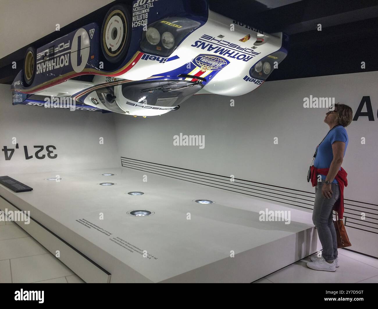 Le visiteur du musée regarde vers le haut une voiture de course Porsche 956 suspendue à l'envers sous le plafond du musée comme un exemple de prés à contact élevé Banque D'Images