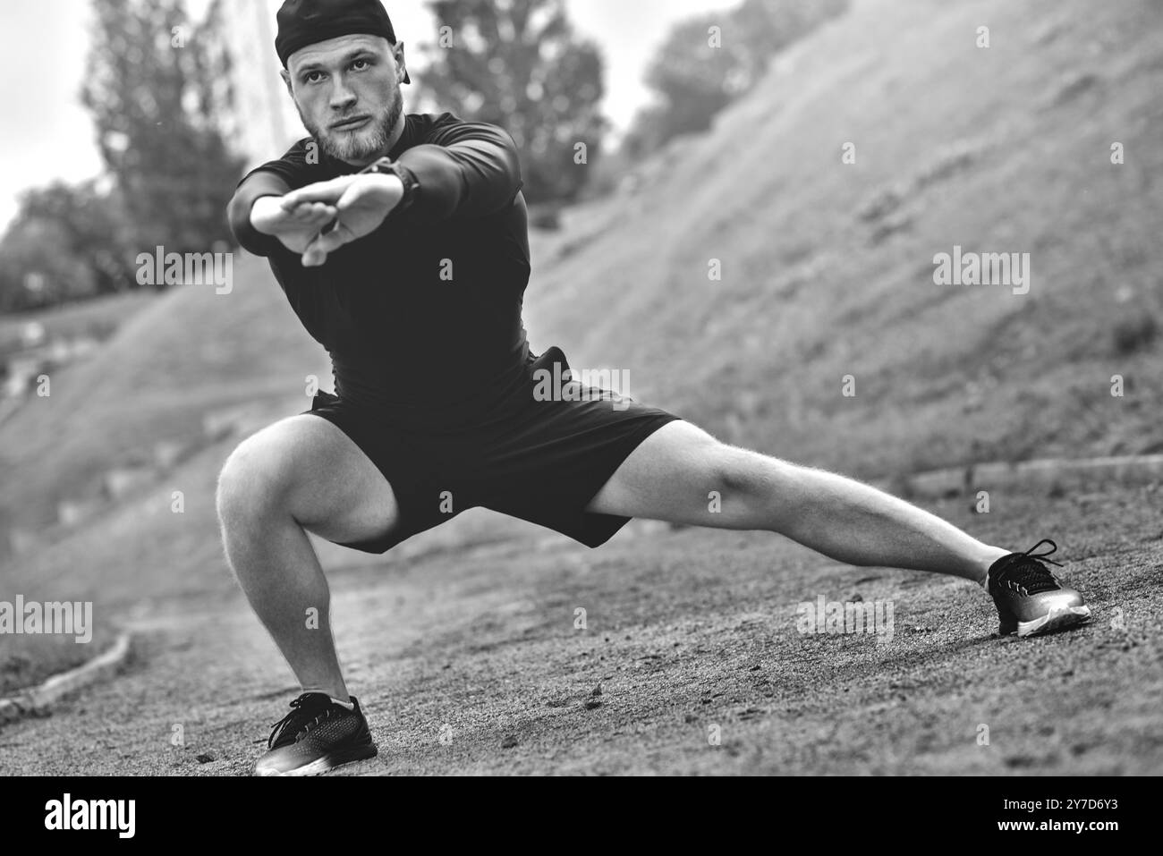 Sportif musculaire étirements avant un entraînement sportif à la rue dans city park Banque D'Images