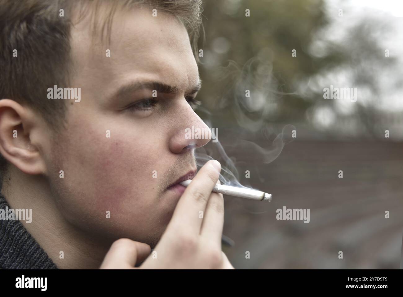 Guy fume une cigarette à l'extérieur, portrait, close-up Banque D'Images