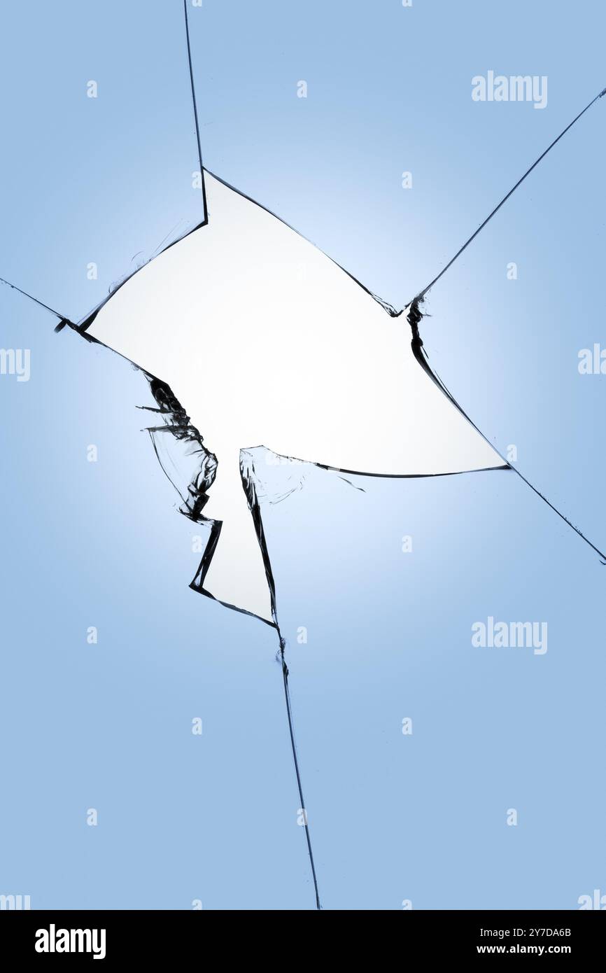 Verre cassé sur fond bleu, fissures dans le verre, fond abstrait avec un trou au centre Banque D'Images