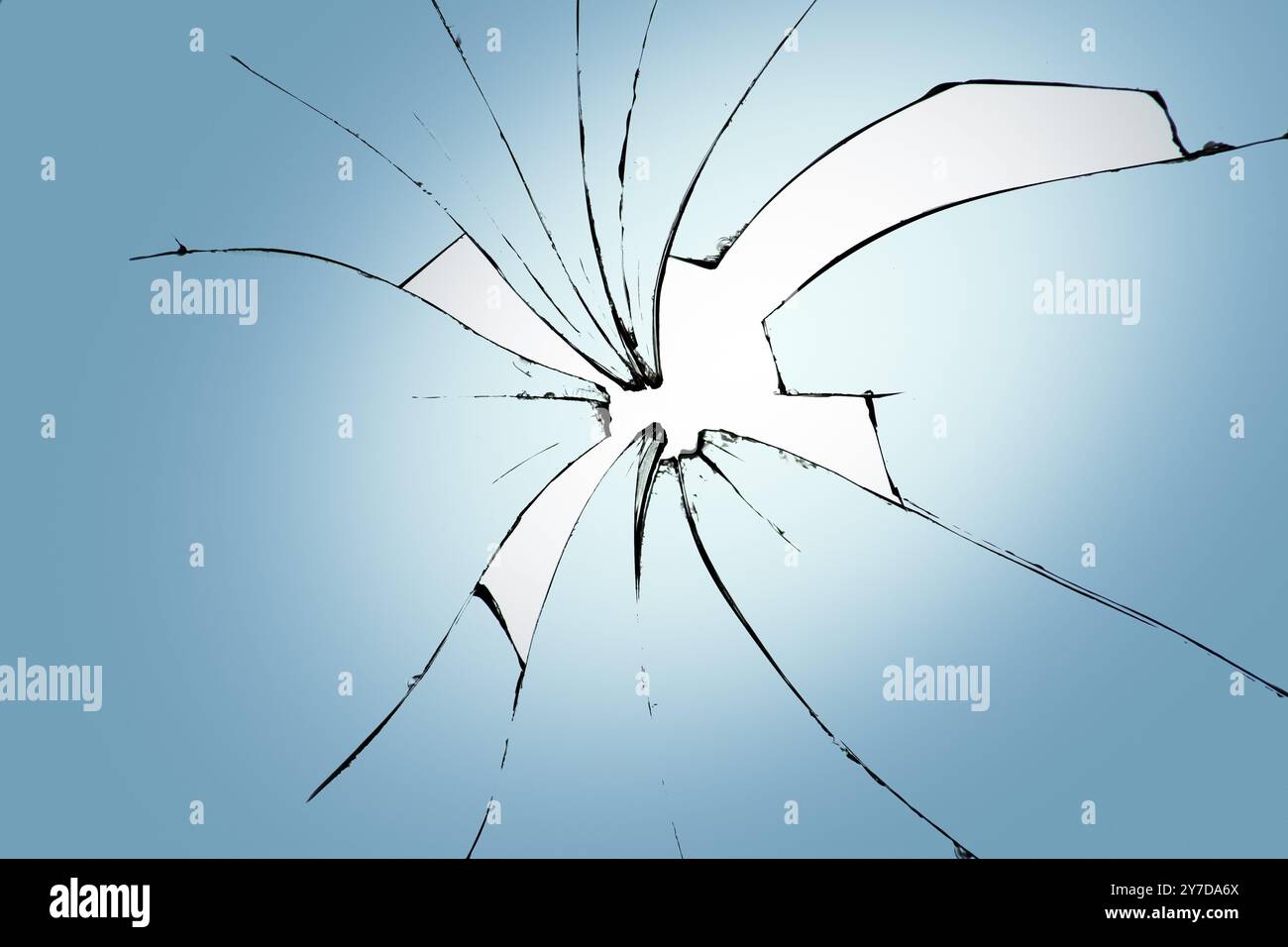 Verre cassé sur fond bleu, fissures dans le verre, fond abstrait avec un trou au centre Banque D'Images