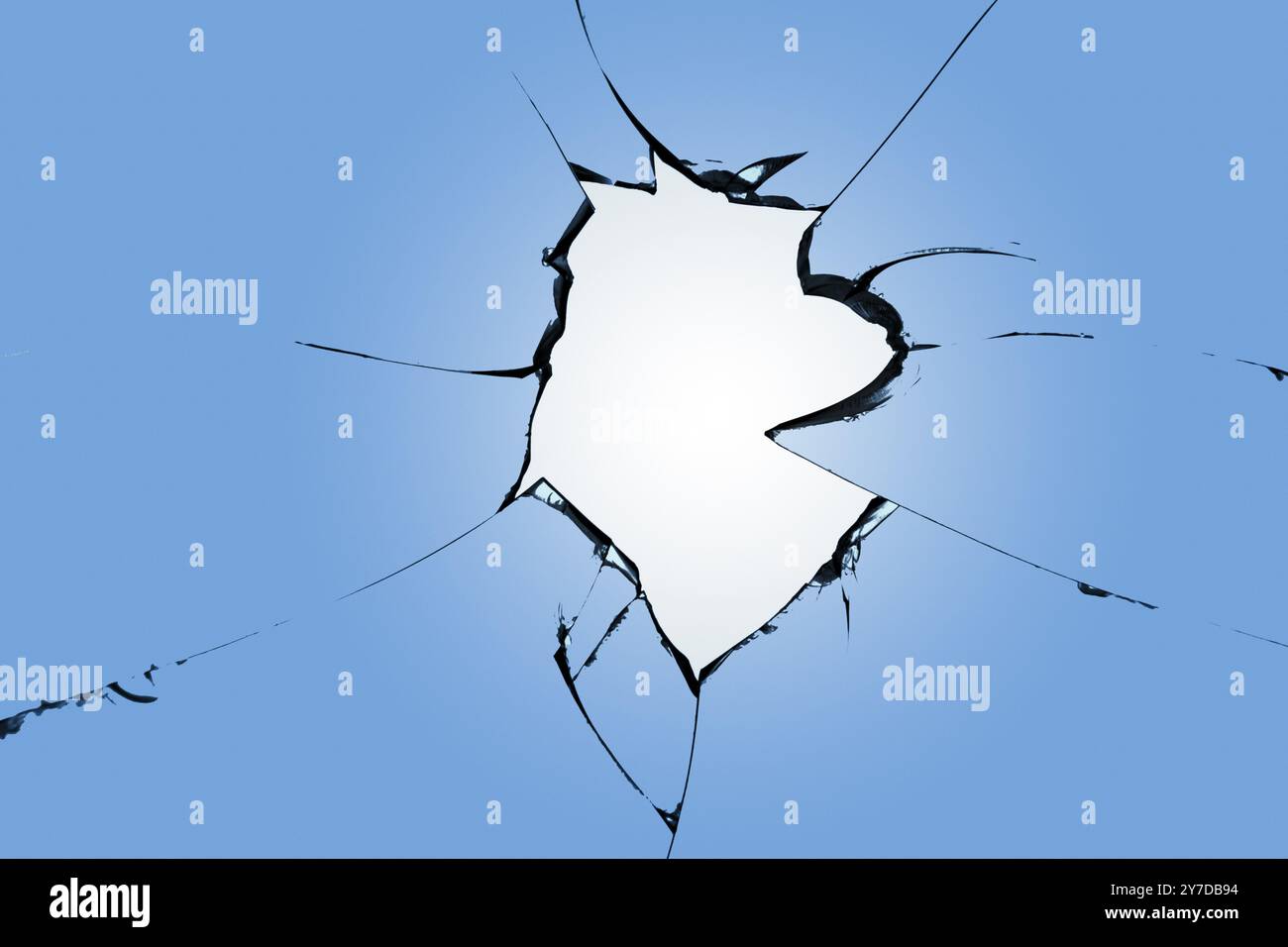 Fissures sur le verre bleu, une fenêtre cassée après le décorticage. Effet de destruction lors du bombardement Banque D'Images