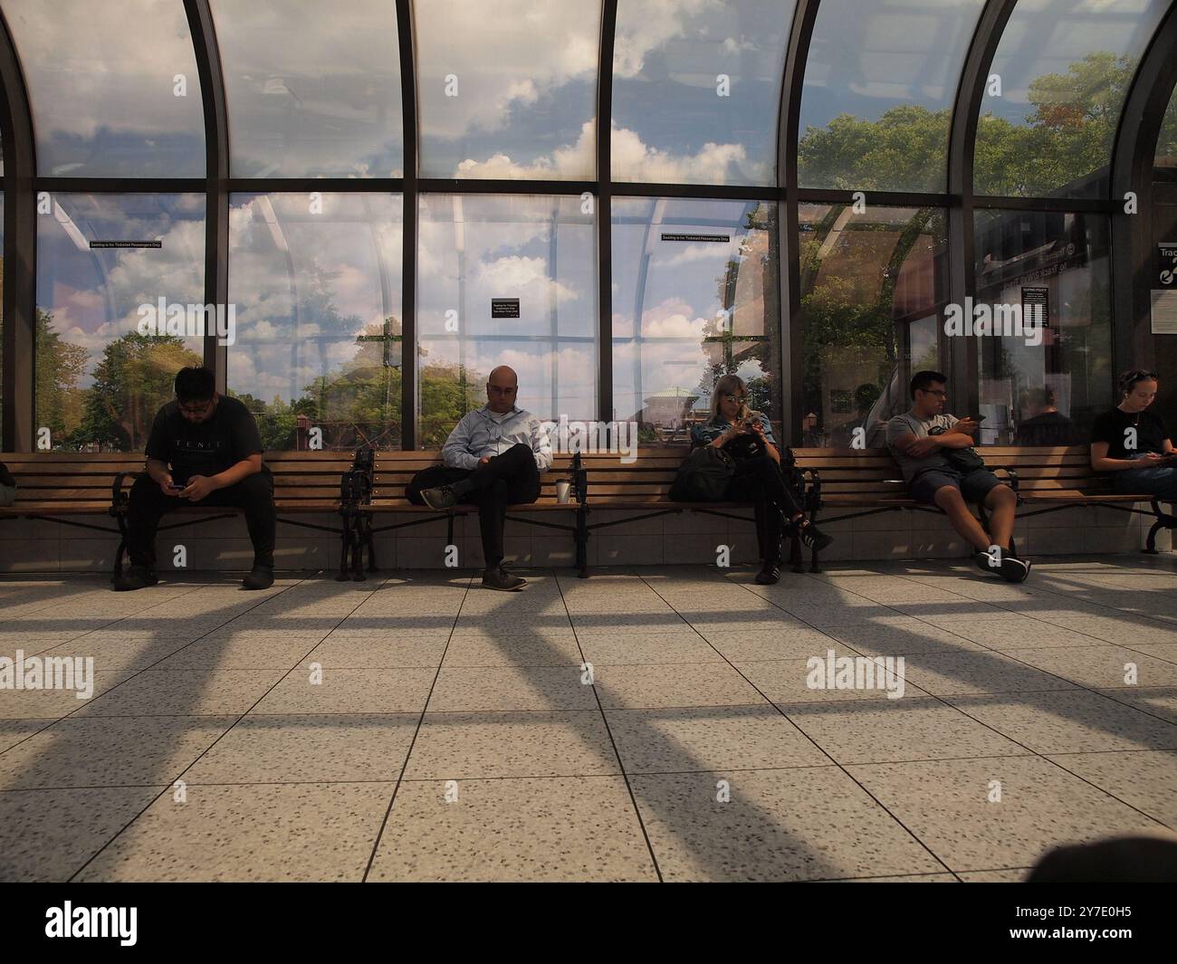 Des étrangers se sont infiltrés dans leurs téléphones à la gare du Summit, New Jersey, alors qu'ils ignoraient les environs. Banque D'Images