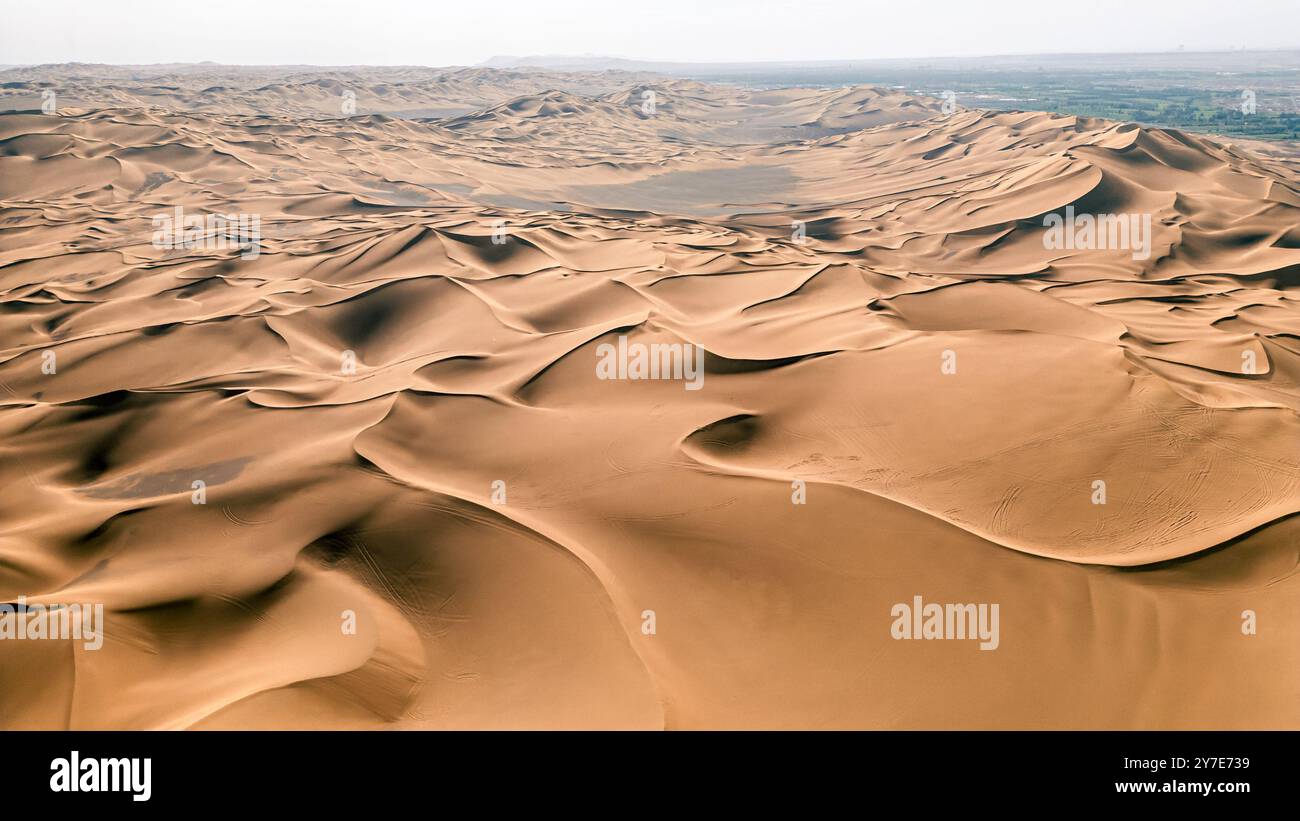 Des dunes de sable roulantes, des lignes rayées, de belles silhouettes, dans le désert de Kumtag, Xinjiang, Chine, photographié depuis le drone, des textures Banque D'Images