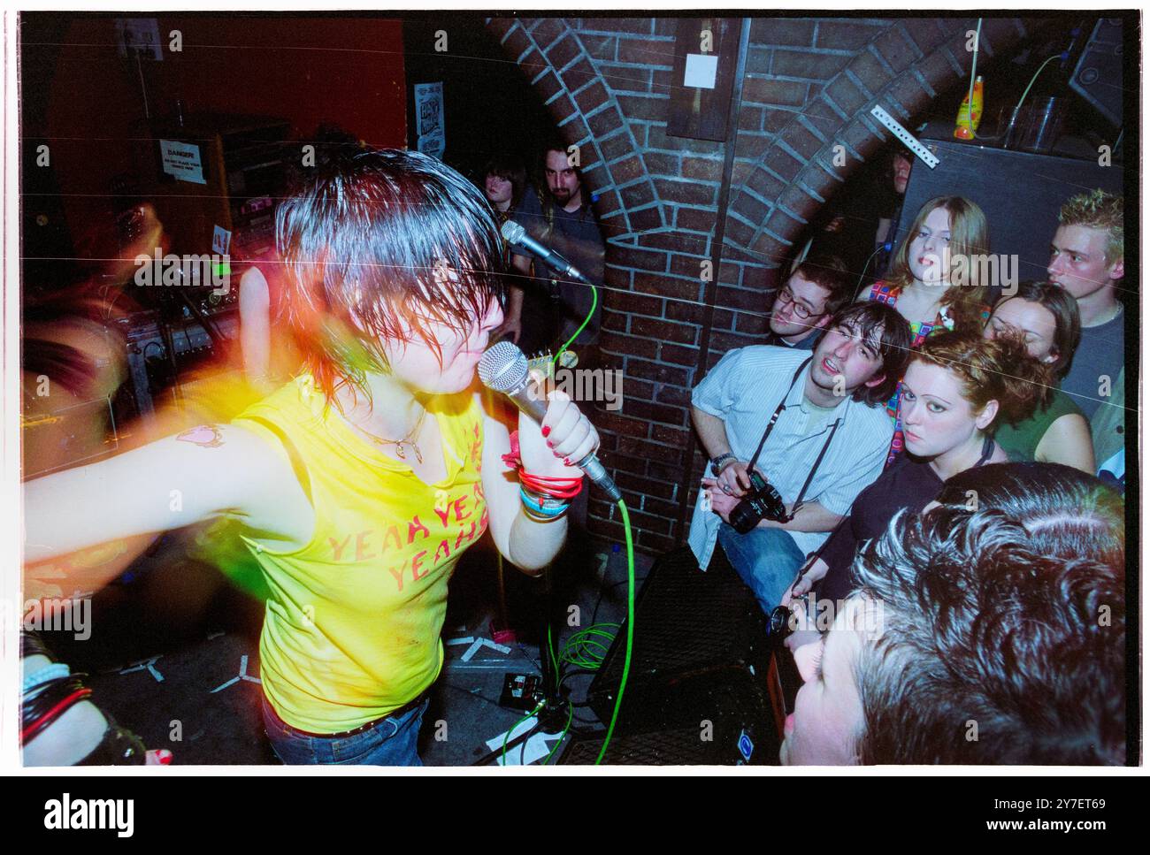 KAREN O, YEAH YEAH YEAHS, PREMIÈRE TOURNÉE britannique, 2002 : une jeune Karen O de Yeah Yeah Yeahs jouant un petit concert en sueur lors de leur première tournée britannique au Barfly Club à Cardiff, pays de Galles, Royaume-Uni le 21 avril 2002. Photo : Rob Watkins. NFO : Yeah Yeah Yeahs est un groupe de rock indépendant américain formé en 2000, connu pour son son art-punk énergique. Face à la chanteuse charismatique Karen O, ils ont gagné en renommée avec des tubes comme « Maps » et « Heads Will Roll », mêlant rock de garage brut à profondeur émotionnelle. Banque D'Images