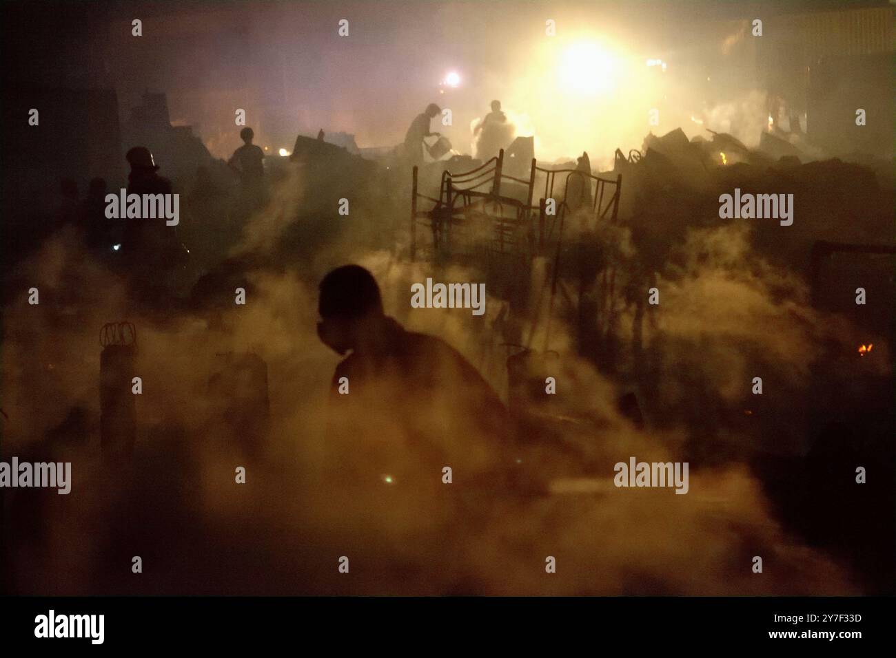 Les pompiers effectuant la phase de refroidissement après un incendie ont incendié des centaines de maisons dans un quartier dense de Jakarta, en Indonésie. Banque D'Images