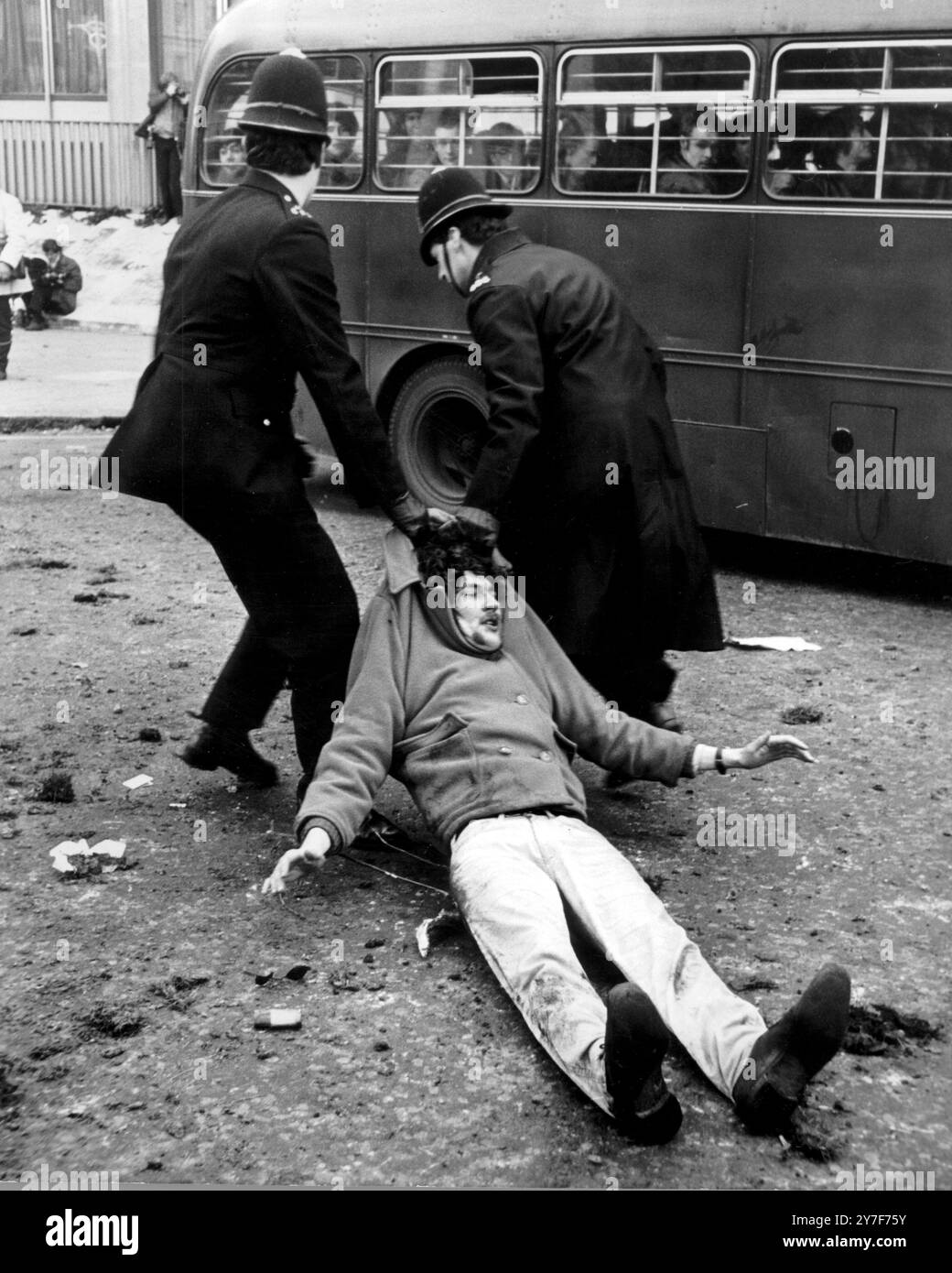 Deux policiers traînent un jeune manifestant dans la bataille du Vietnam sur Grosvenor Square à Londres devant l'ambassade américaine aujourd'hui lorsque des milliers de manifestants ont assiégé l'ambassade pour protester contre la guerre du Vietnam. Les manifestants se sont battus avec la police et de nombreuses arrestations ont eu lieu. 17 mars 1968 Banque D'Images