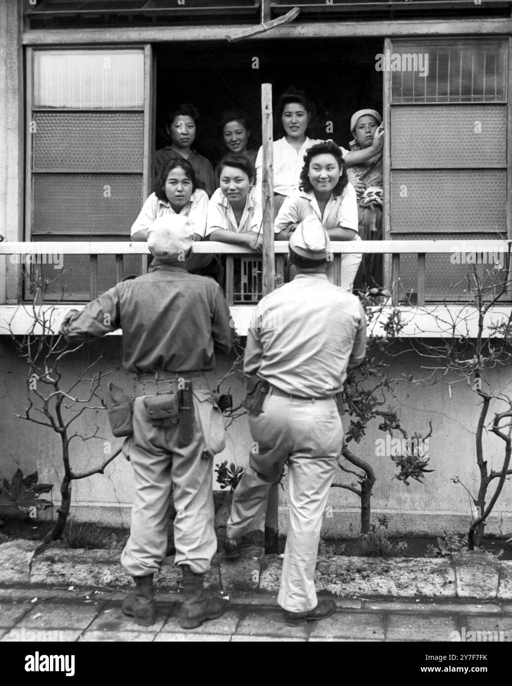 Deux G.I.S stationnés à Yokohama, au Japon, essayent leur japonais sur un groupe de filles autochtones. 31 août 1945 Banque D'Images