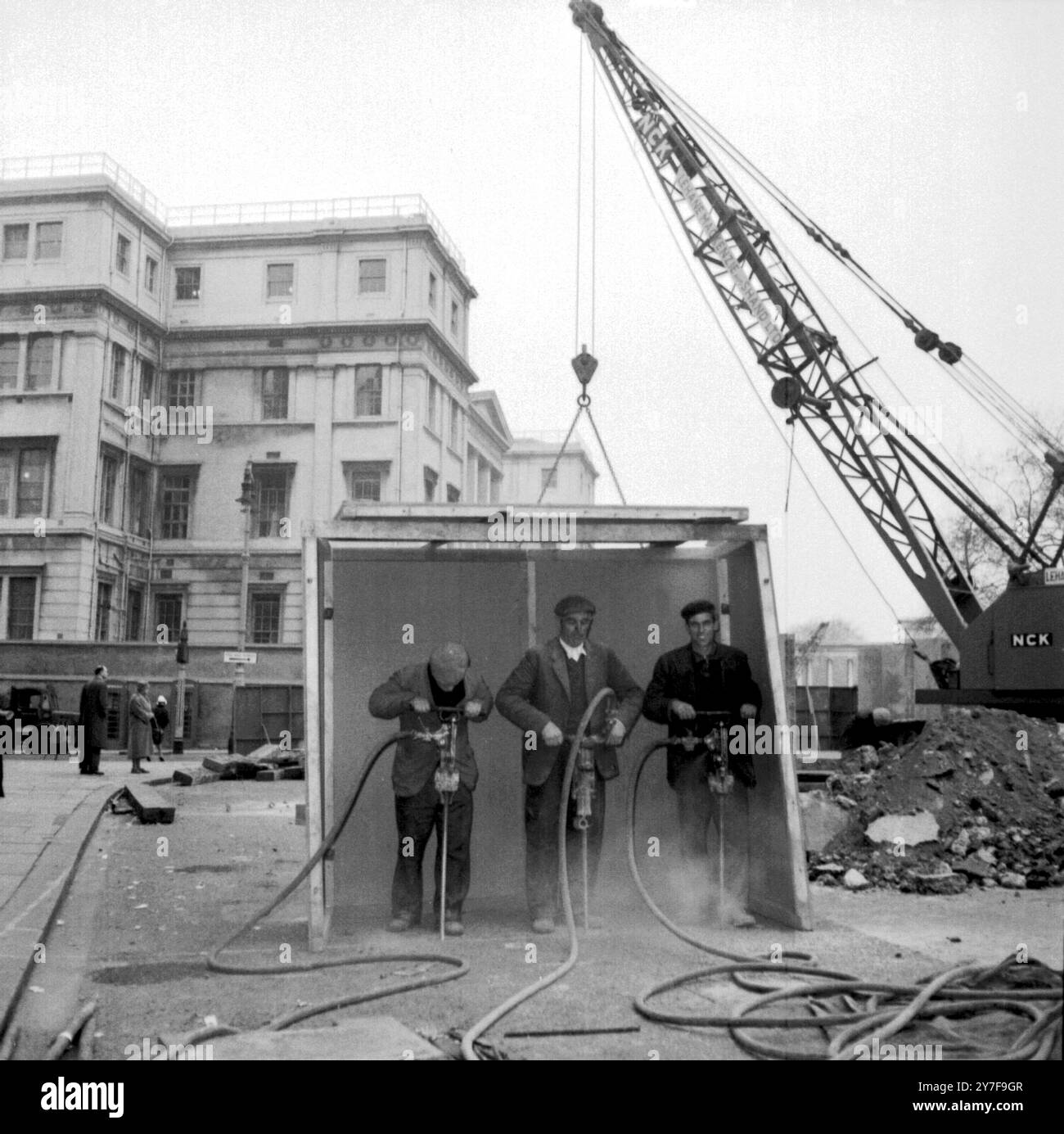 Un abri spécialement conçu pour protéger du son. Des ouvriers brisent la surface de la route à l'extérieur de l'hôpital George's à Hyde Park Corner avec des perceuses pneumatiques. Fait partie du programme de reconstruction de Hyde Park Corner de 5 millions de livres sterling. Londres - 16 février 1961 Banque D'Images