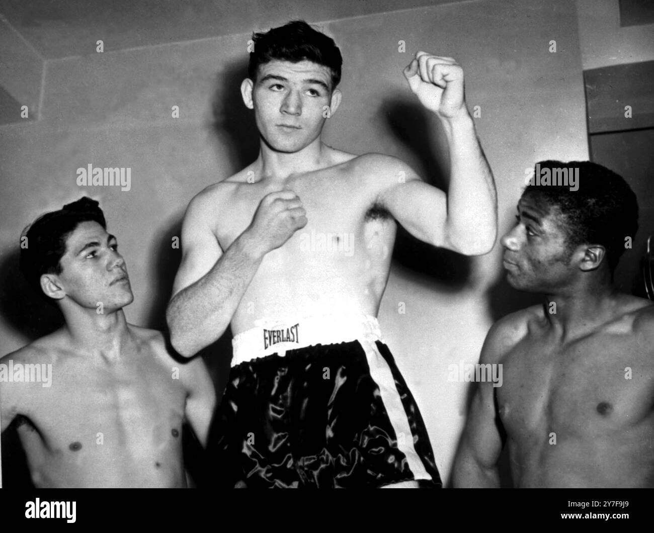 New York : Lalu Sabotin (à gauche) de Warren, Ohio, et Floyd Patterson (à droite), de Brooklyn, New York, se demandent si John L. Sullivan (au centre), un nouveau venu, de Preston, Angleterre, sera jusqu'au célèbre nom fistic qu'il a dans la demi-finale de huit rondes avec Irwin Schultz. Les trois se sont rencontrés lors de pesées au bureau de la Commission de boxe de l'État de New York. 29 décembre 1962 Banque D'Images