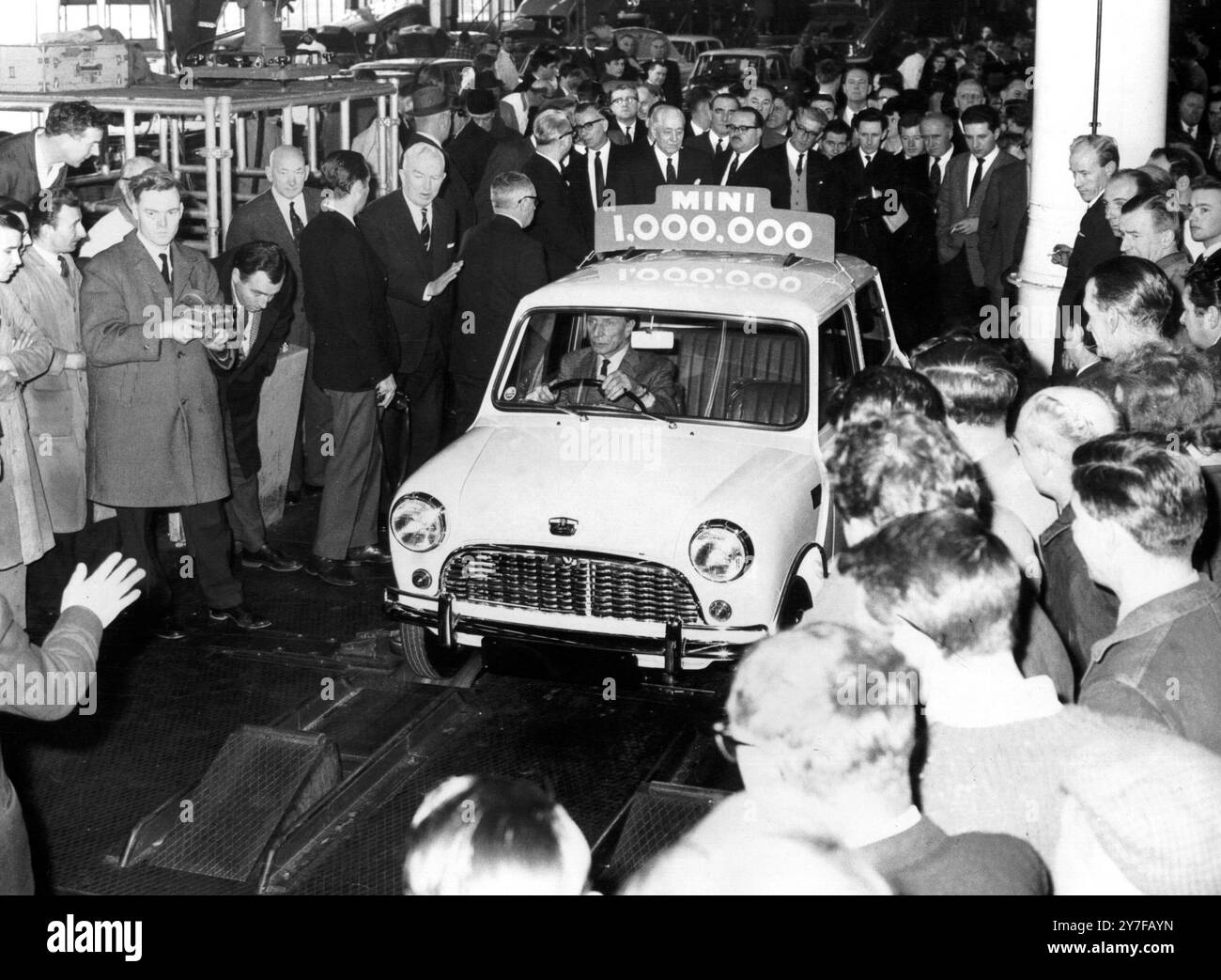 Millionième "Mini" sort de la ligne, 2 février 1965 M. Alec Issigonis, créateur de la gamme de voitures "Mini" de British Motor Corporation, est photographié alors qu'il conduisait le 1 000 000ème "Mini" hors de la ligne de production à Longbridge, Birmingham, usine d'Austin. La voiture a été achetée par un couple de Heswell, Cheshire - M. et Mme Peter James - qui étaient aux travaux pour prendre livraison. Cette voiture est devenue la millionième « Mini » en additionnant le nombre total de véhicules vendus dans la gamme « Mini ». Ils comprennent Austin et Morris Mini Cars, Austin et Morris Mini fourgonnettes et pick-ups, Austin Countrymen A. Banque D'Images