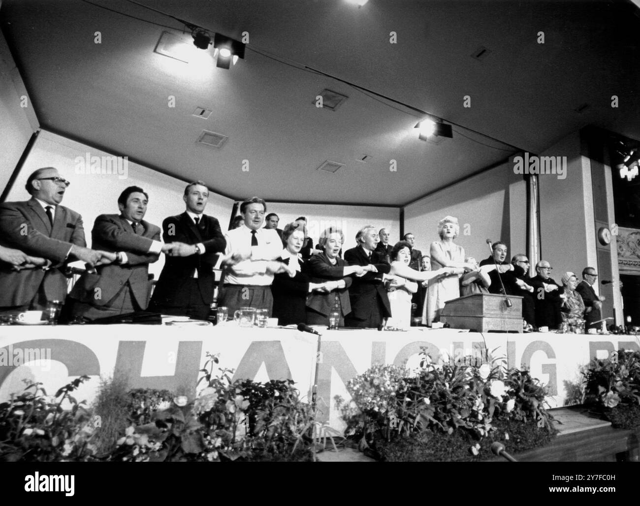 Les bras croisés, les dirigeants du Parti travailliste chantent le drapeau rouge à la fin de leur conférence annuelle ici aujourd'hui. De gauche à droite, deux non identifiés ; M. Anthony Wedgwood Benn, W E Padley, Barbara Castle, Alice Bacon, Harold Wilson, Mme White, Mlle Sara Barker, Jennie Lee, Mlle Betty Lockwood, James Callaghan, George Brown, Ian Mikardo, Anthony Greenwood, A Skeffington, Bessie Braddock, et Harry Nicholas. 4 octobre 1968 Banque D'Images