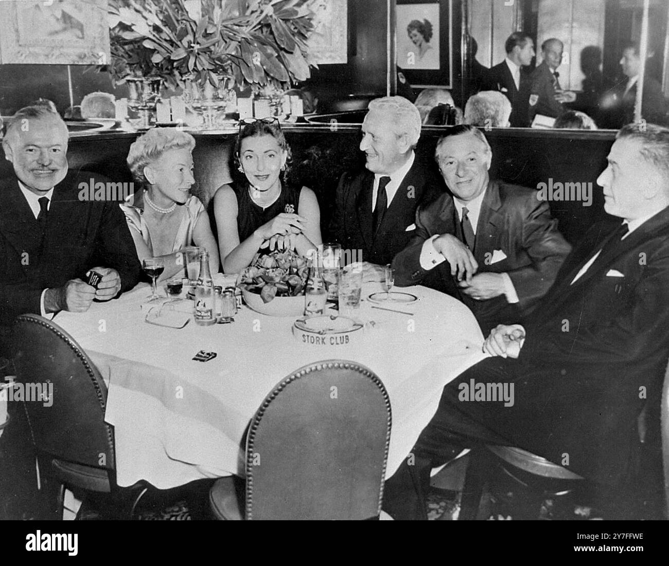 Ernest Hemingway, sa femme, MRS Leland Hayward, l'acteur Spencer Tracy, le producteur - acteur George Jessel, et le producteur de théâtre - télévision - écran Leland Hayward, tous profitant d'un dîner et d'une discussion dans une boîte de nuit New-yorkaise, y compris des négociations pour faire un film du livre de Hemingway lauréat du prix nobel "le vieil homme et la mer". 30 juin 1953 Banque D'Images