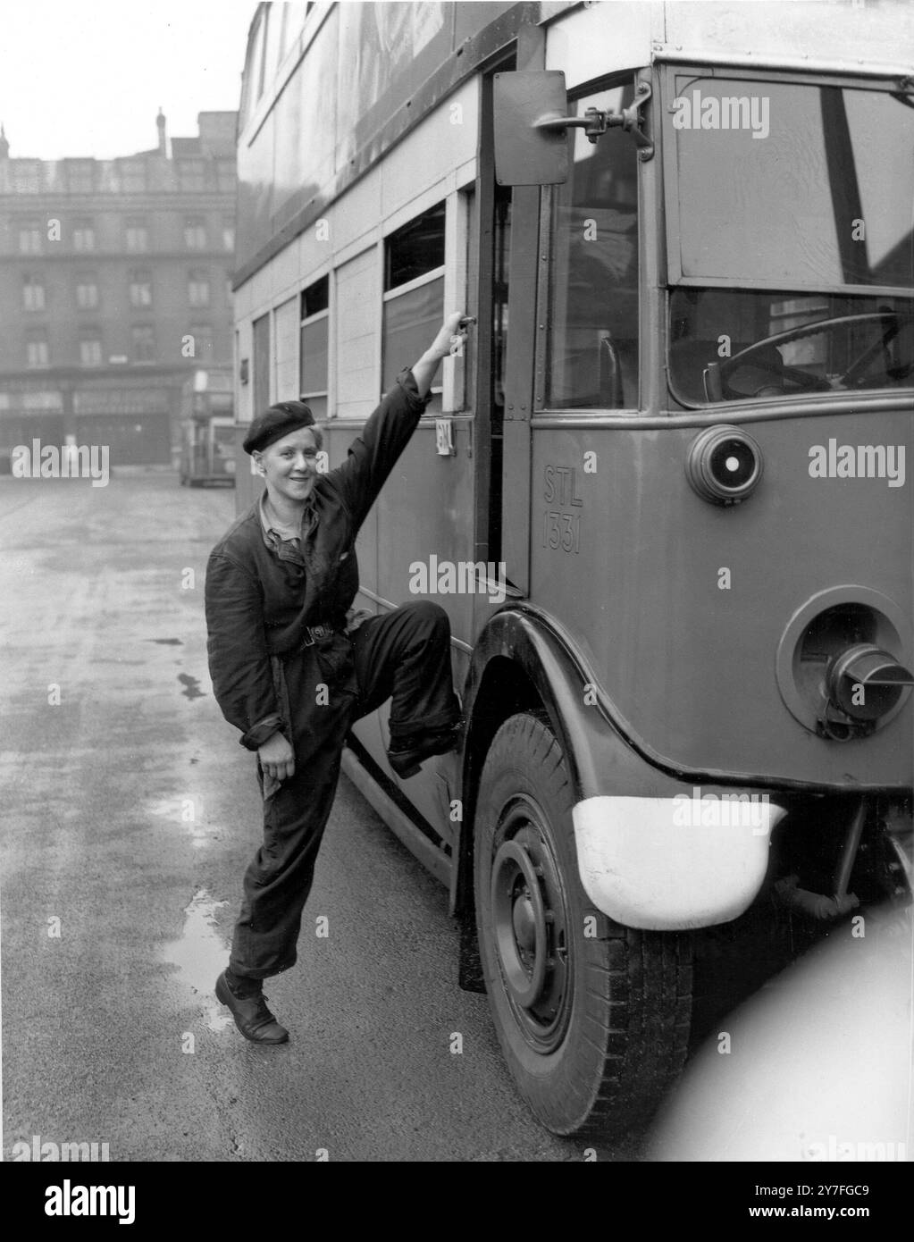 Dolores Rennie cinq pieds un pouce et demi de haut est la première femme à obtenir le certificat du ministère des Transports de la guerre pour la compétence pour conduire un autobus à Londres. Le chauffeur de bus miniature de Londres doit faire un grand pas pour entrer dans la cabine d'un bus Banque D'Images