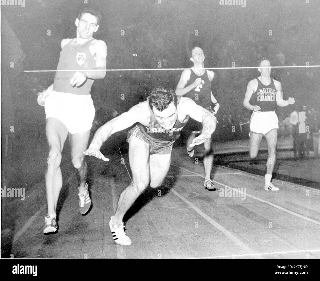 Peter Scott, de Lincoln, trébuche alors qu'il franchit la ligne d'arrivée dans la course Invitational de 800 yards sur la piste intérieure des Chevaliers de Colomb à Madison Square Garden. Suivent Noel Carroll (à gauche), qui a été classé 1er après que Scott a été disqualifié pour interférence, Brian Hernin 2e et Peter Farrell (à droite) 3rd. 17 mars 1967 Banque D'Images