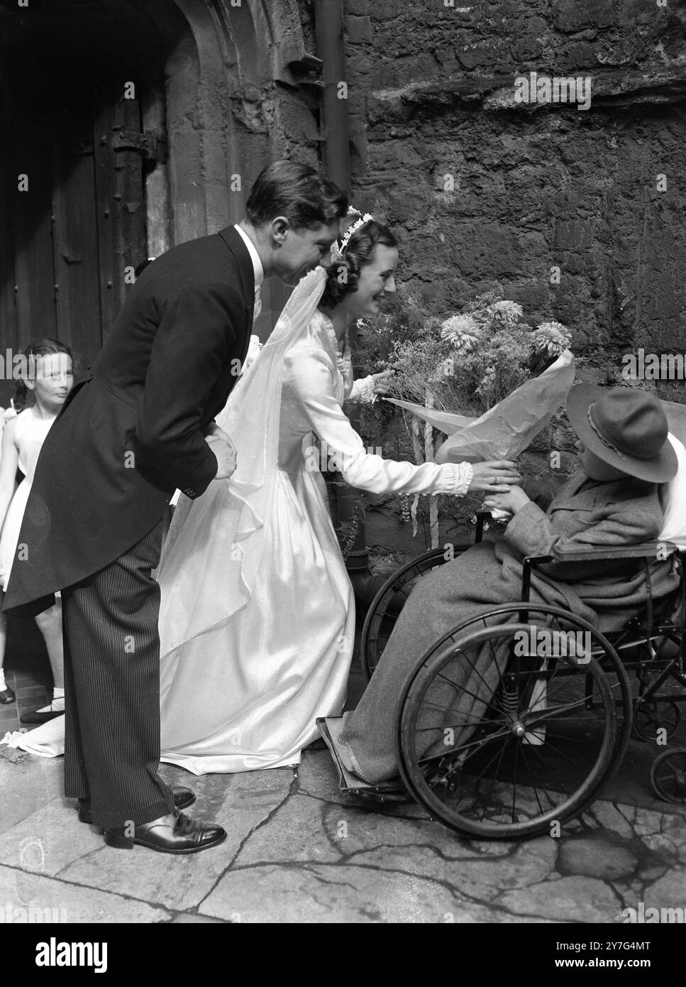 Scout Roy Ford présente un bouquet à la mariée alors qu'elle quitte l'église. Scout Roy est un patient à Highfield Hospital , que Maureen visite souvent . 11 septembre 1948 Banque D'Images