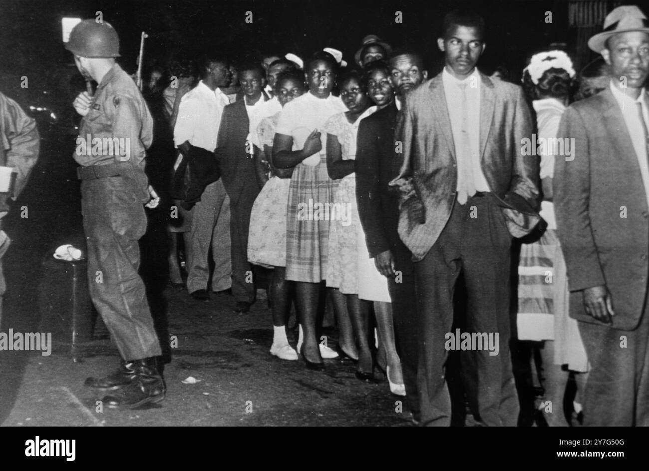 490939 'SOLDATS DE LA SÉCURITÉ' MONTGOMERY, ALABAMA, ÉTATS-UNIS : LES TROUPES DE LA GARDE NATIONALE MONTENT LA GARDE CONTRE DE NOUVELLES FLAMBÉES DE VIOLENCE, ICI TÔT LE 22 MAI 1961 ALORS QUE LES AFRO-AMÉRICAINS QUITTENT LA PREMIÈRE ÉGLISE BAPTISTE POUR LEURS MAISONS. DES MARSHALS AMÉRICAINS ET DES OFFICIERS DE POLICE LOCAUX ONT EMPÊCHÉ UNE MAFIA EN COLÈRE D'ATTAQUER L'ÉGLISE OÙ LE LEADER DE L'INTÉGRATION, REV. MARTIN LUTHER KING, JNR., PARLAIT. LES TROUPES DE LA GARDE NATIONALE ONT ÉTÉ APPELÉES PAR LE GOUVERNEUR DE L'ALABAMA PATTERSON POUR PRÉVENIR LA VIOLENCE. LES TROUPES ONT ESCORTÉ LES GENS JUSQU'À LEURS MAISONS. 22 MAI 1961 Banque D'Images