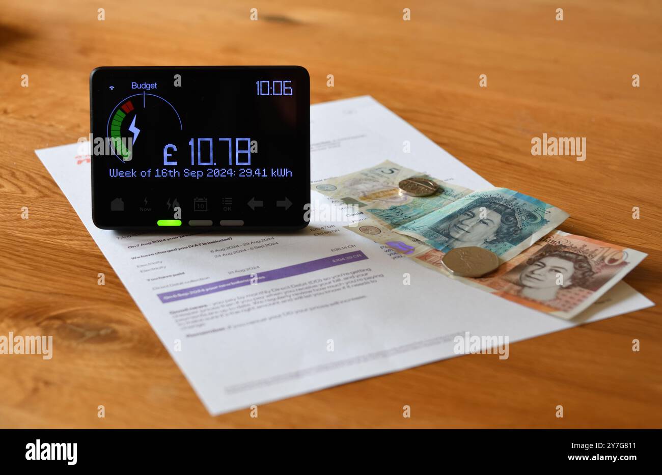 Compteur intelligent d'électricité en affichage à la maison (IHD) sur la table en bois montrant le coût et l'utilisation de la semaine précédente en kilowattheures (kWh) Banque D'Images