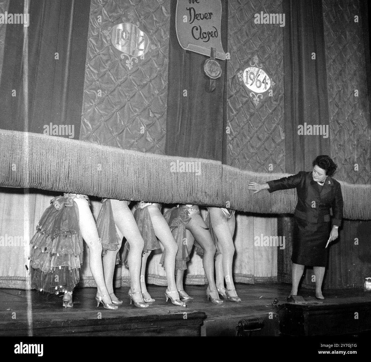 31 OCTOBRE 1964 la propriétaire du Windmill Theatre, Sheila van Damm, regarde pour la dernière fois que le rideau tombe sur les jambes des danseurs alors que l'ère du célèbre Windmill Theatre touche à sa fin. Le théâtre qui est resté ouvert tout au long de la guerre au slogan « nous n'avons jamais fermé » est appelé à devenir un cinéma. Londres, Angleterre. Banque D'Images