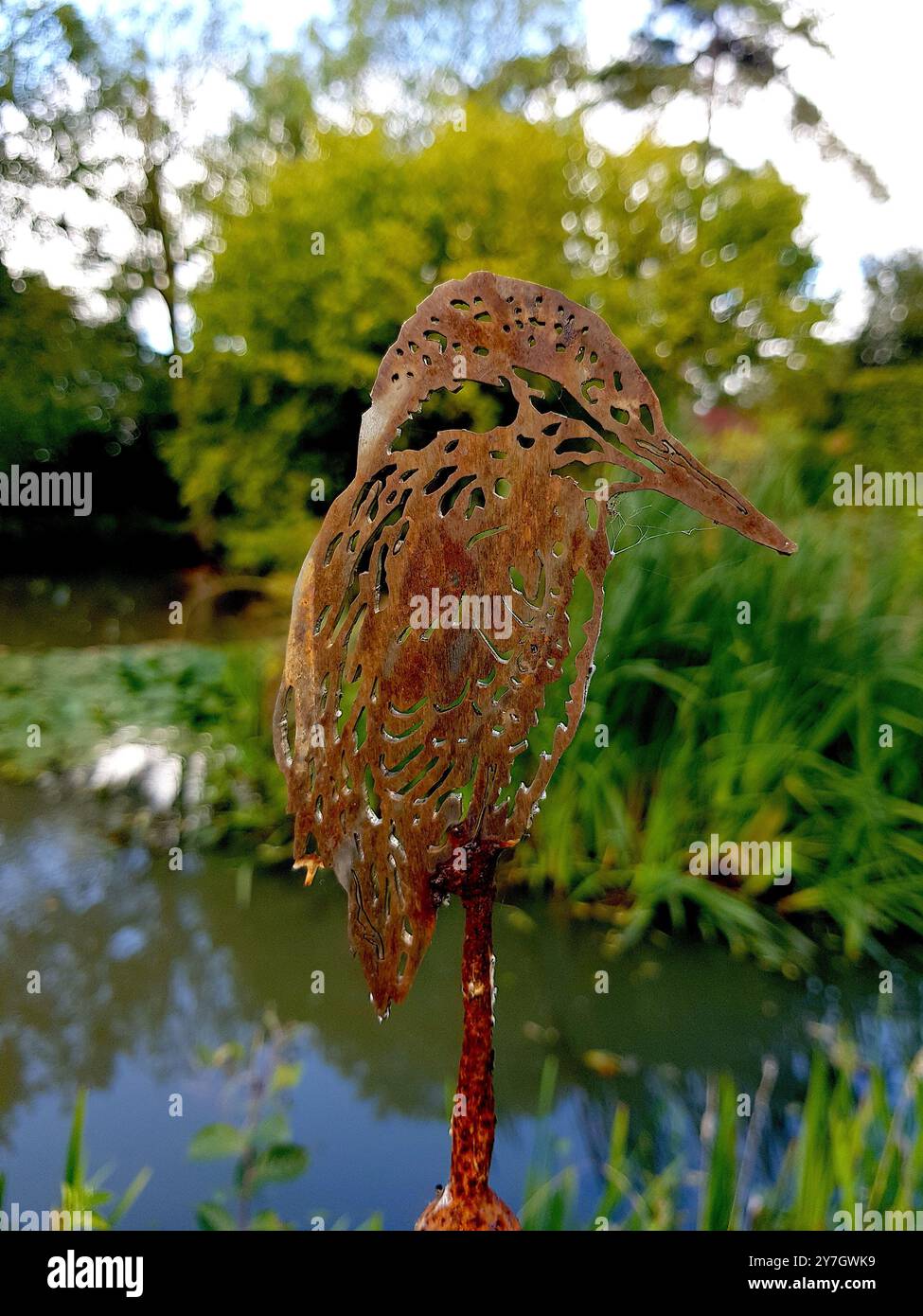 Détail d'une sculpture d'oiseau kingfisher dans un cadre de jardin. Banque D'Images