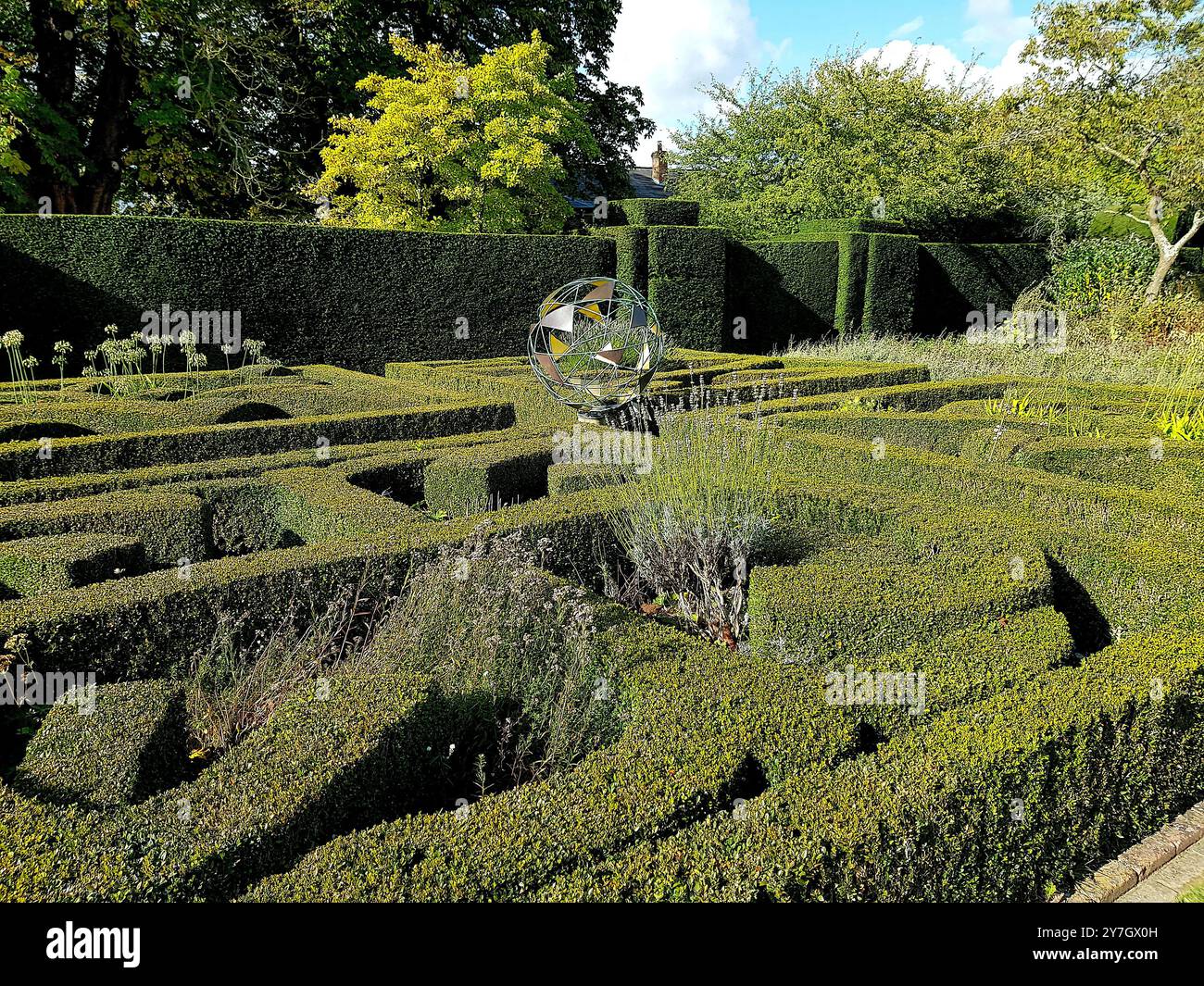 Vue d'un jardin historique avec une sculpture de globe dans le comté de Suffolk, Royaume-Uni. Banque D'Images