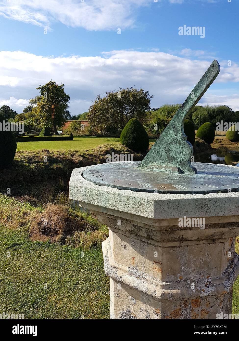 Vue d'un jardin historique avec un cadran solaire au premier plan dans le comté de Suffolk, Royaume-Uni. Banque D'Images