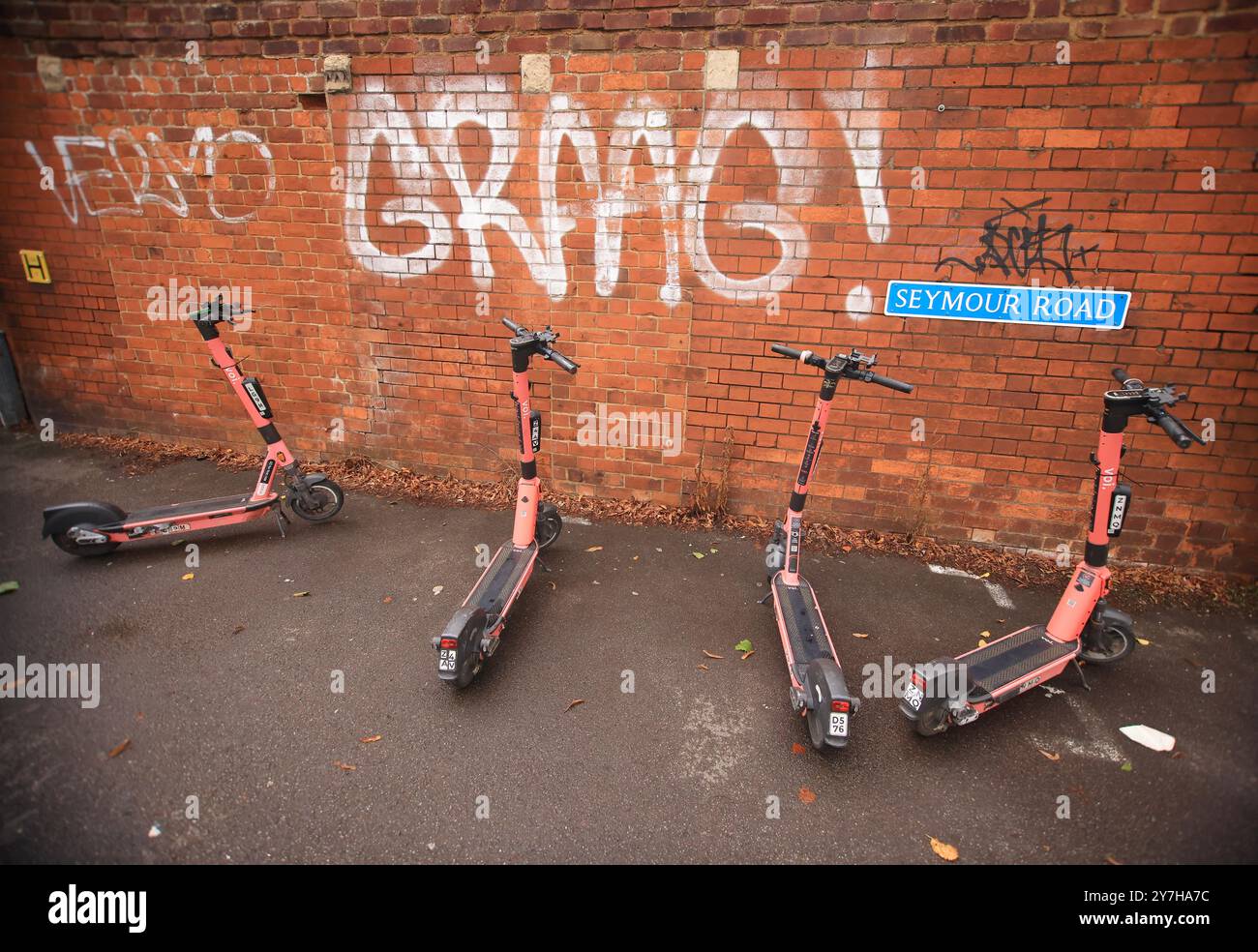 Une scène urbaine moderne avec des vélos électriques et un mur de graffiti dans une ville animée Banque D'Images