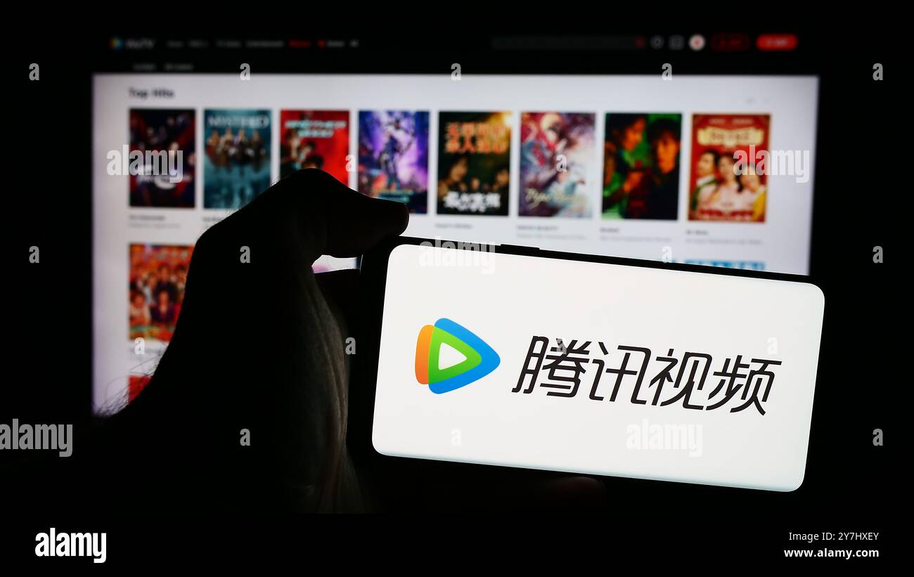 Dans cette illustration photo, un homme vu tenant un smartphone avec le logo du service chinois de streaming vidéo Tencent Video (WeTV) en face de la page web. (Photo timon Schneider / SOPA images/SIPA USA) *** strictement à des fins éditoriales *** Banque D'Images