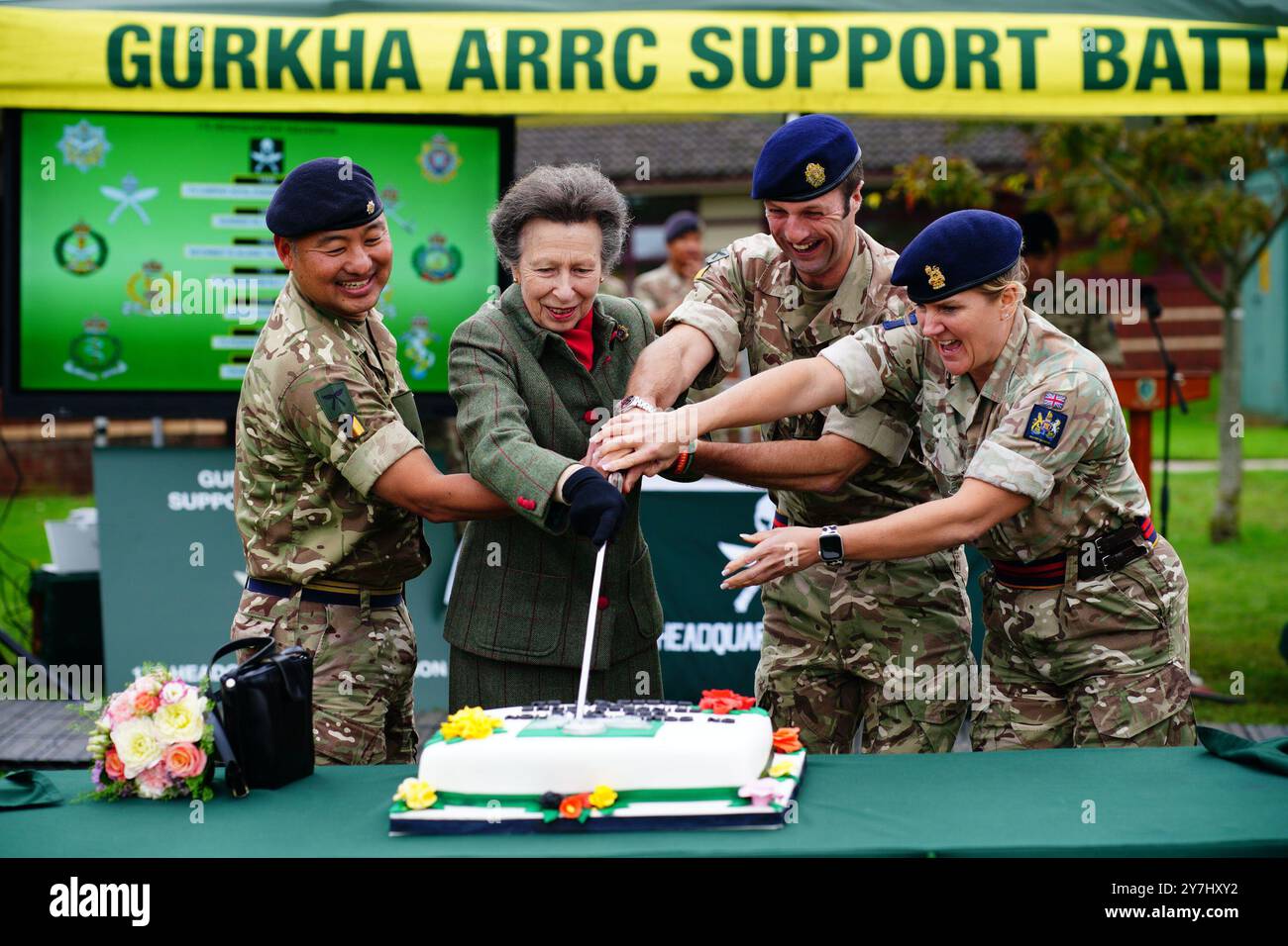 La princesse royale, colonel en chef du Royal Logistic corps, coupe un café de célébration avec un grand kukri (khukuri en népalais) le couteau traditionnel utilisé par Gurkhas, lors d'une visite au bataillon de soutien du corps de réaction rapide allié Gurkha (ARRC) à la caserne d'Imjin à Innsworth, Gloucestershire. Date de la photo : lundi 30 septembre 2024. Banque D'Images