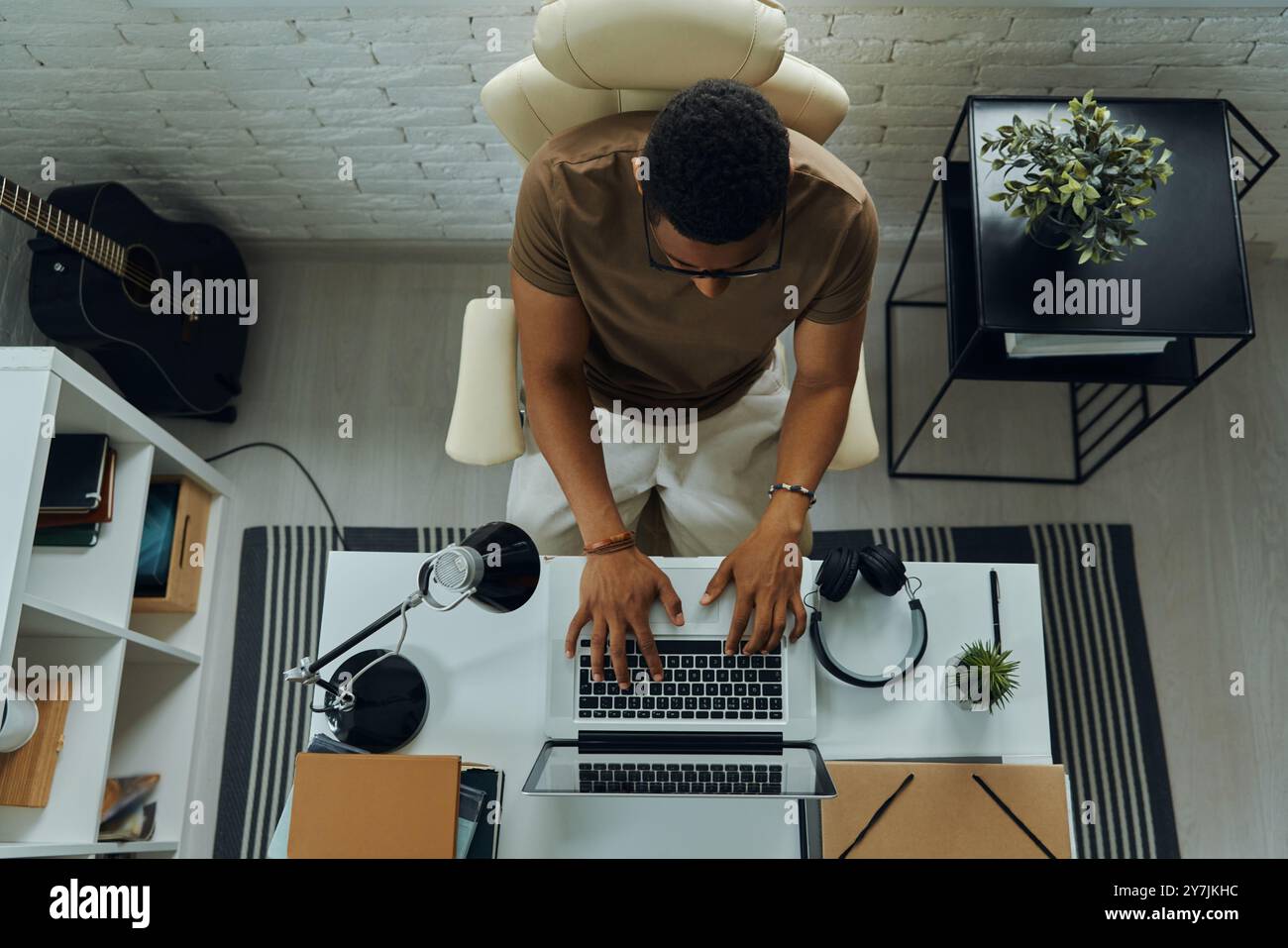 Vue de dessus d'un jeune homme de race mixte travaillant dans le bureau Banque D'Images