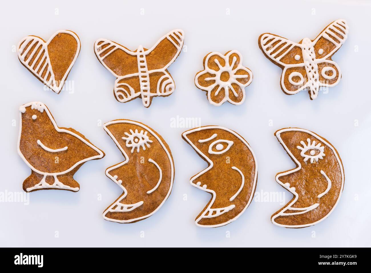 Gros plan de biscuits en pain d'épice décorés aromatiques sur fond blanc. Ensemble de lunes cuites au four mignonnes, papillons et bonbons en forme d'oiseau, de coeur ou de fleur. Banque D'Images