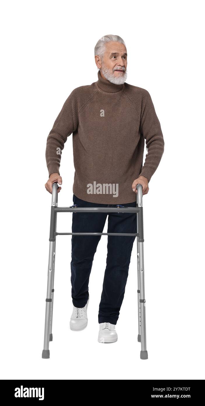 Homme senior utilisant le cadre de marche sur fond blanc Banque D'Images