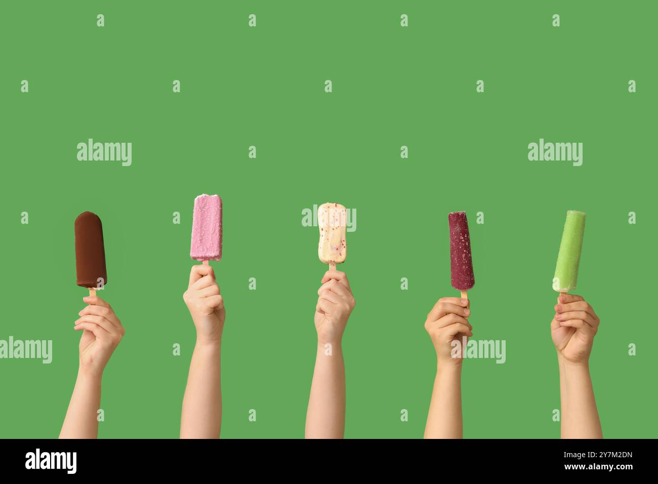 Mains féminines avec différentes glaces sucrées sur fond vert Banque D'Images