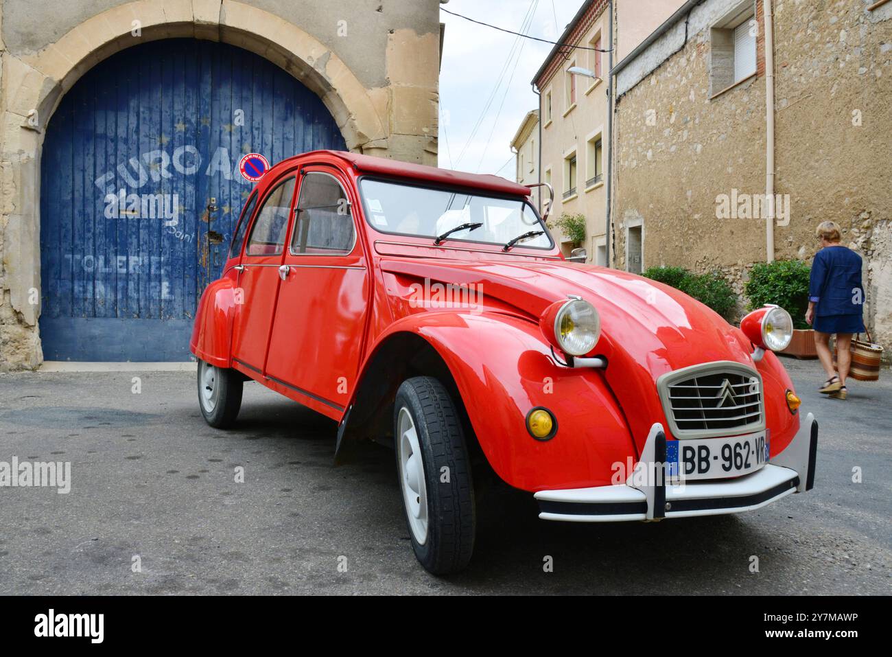 HÉRAULT (34). SAINT-CHINIAN. VOITURE ROUGE CITROEN 2CV GARÉE DEVANT UN GARAGE Banque D'Images